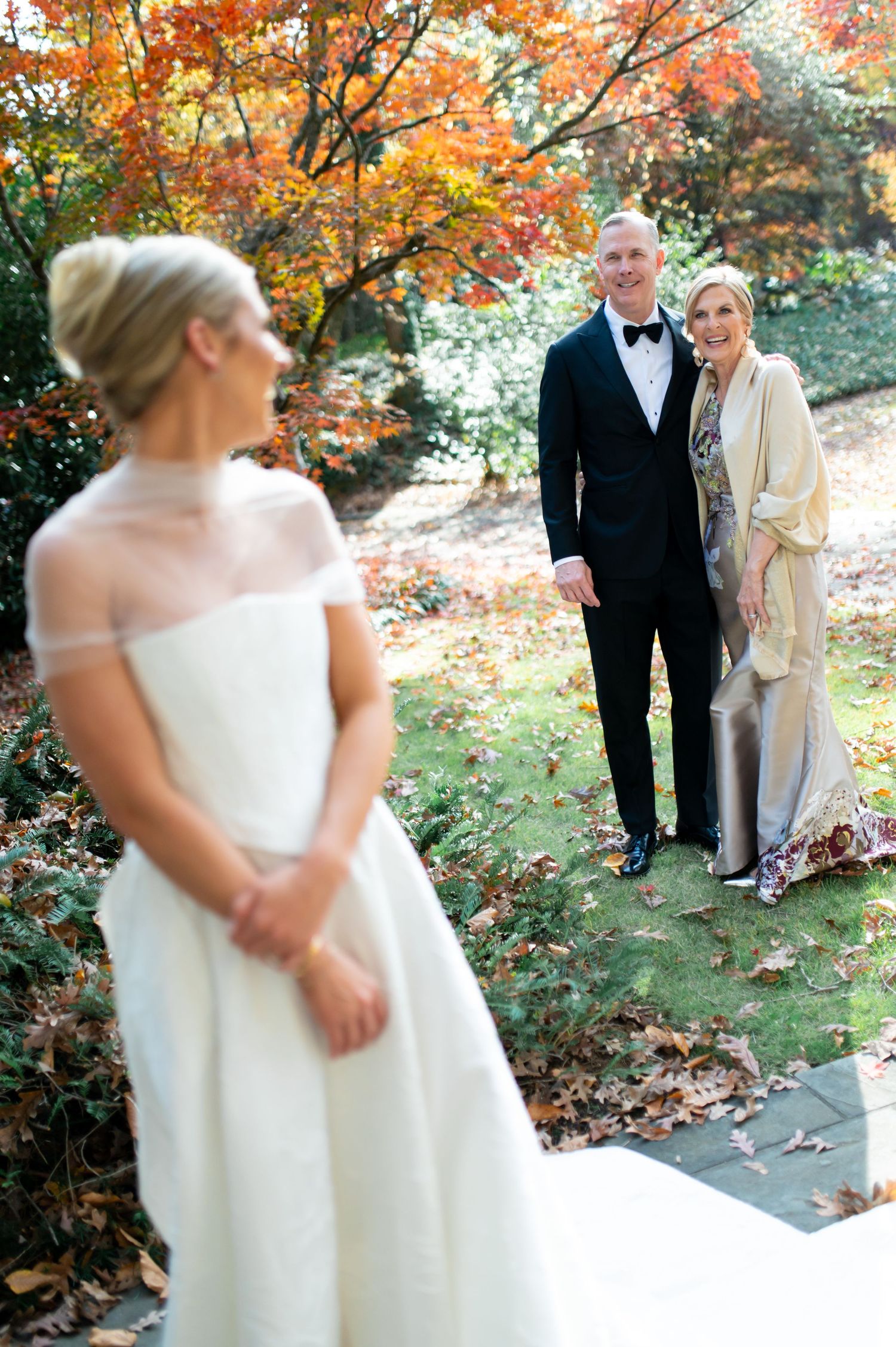 Wedding portrait featuring couple in formal attire amid fall foliage.