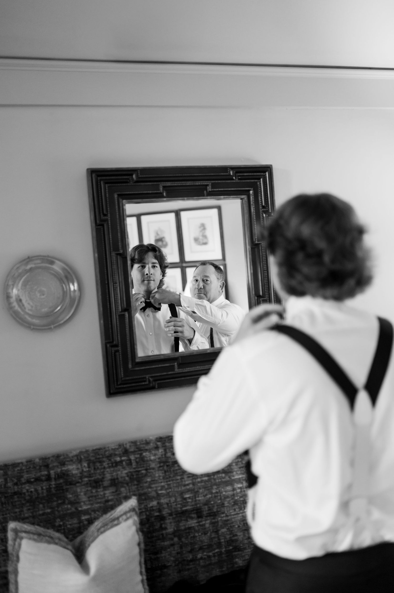 Photographers in formal attire take pictures in a black and white composition.