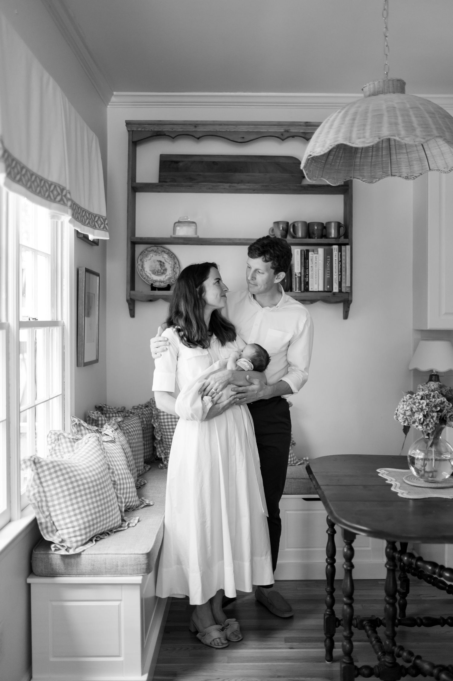 Black and white photos of a couple sharing intimate moments in a cozy home interior.