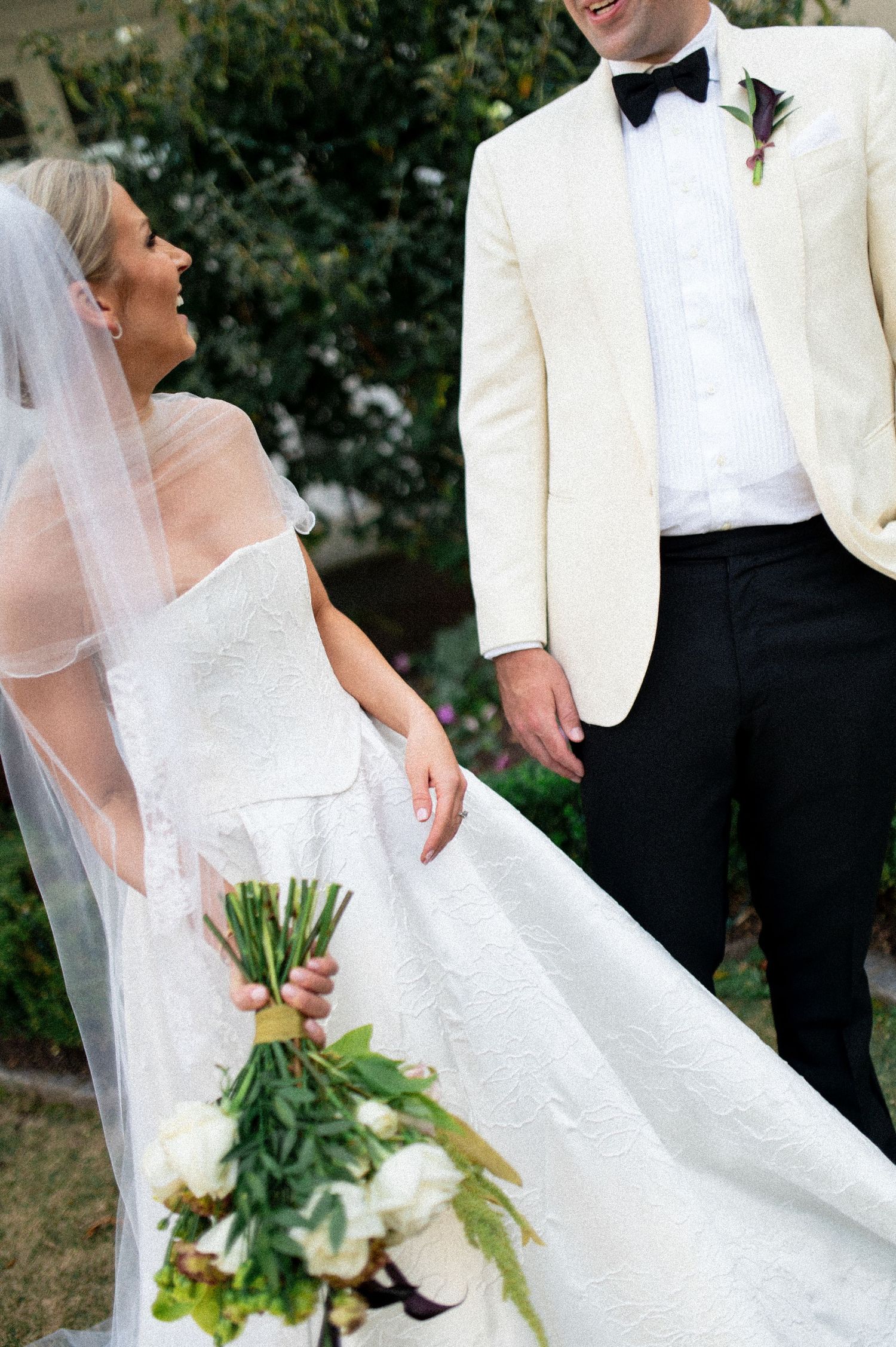 Wedding detail shots featuring bride's white dress and bouquet against classic architecture.