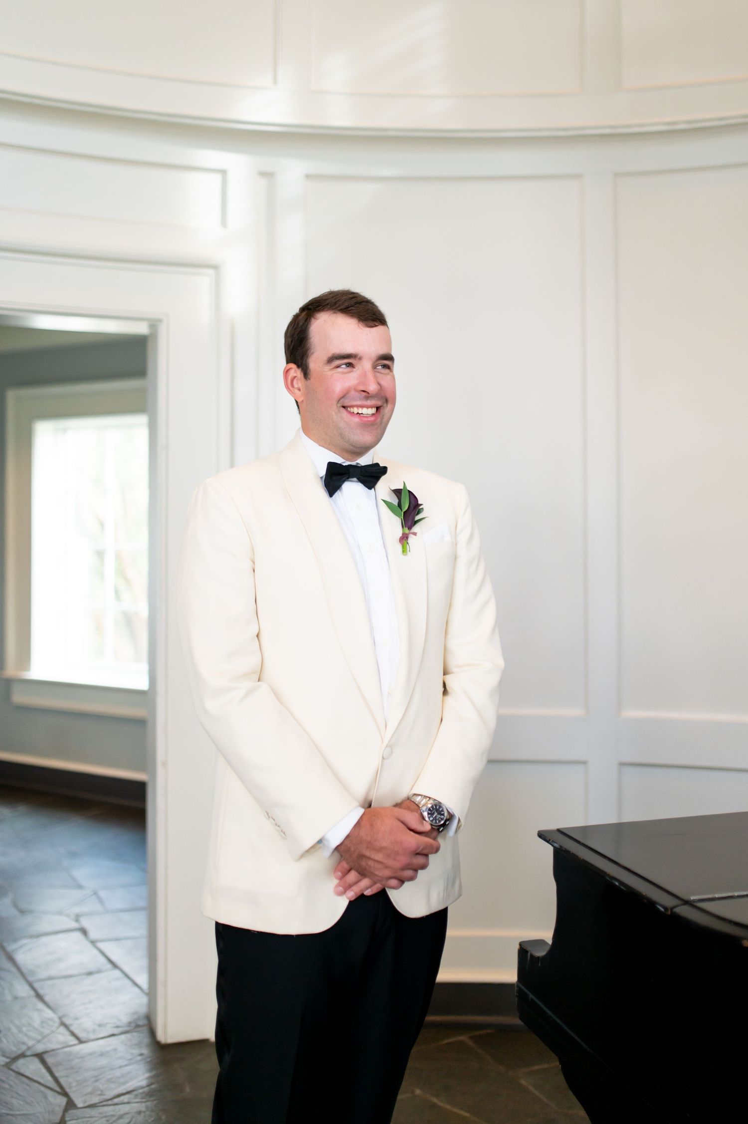 Classic wedding portraits in a white paneled room with a grand piano.