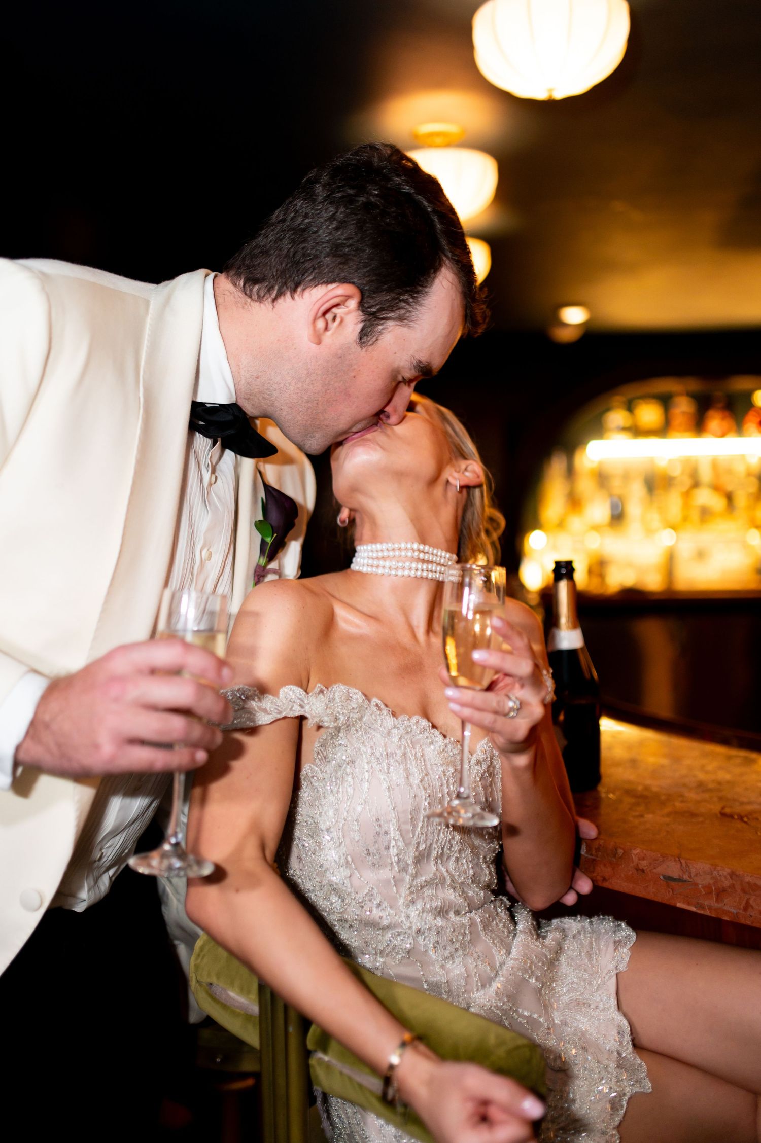 Wedding couple sharing drinks together at an intimate bar setting.