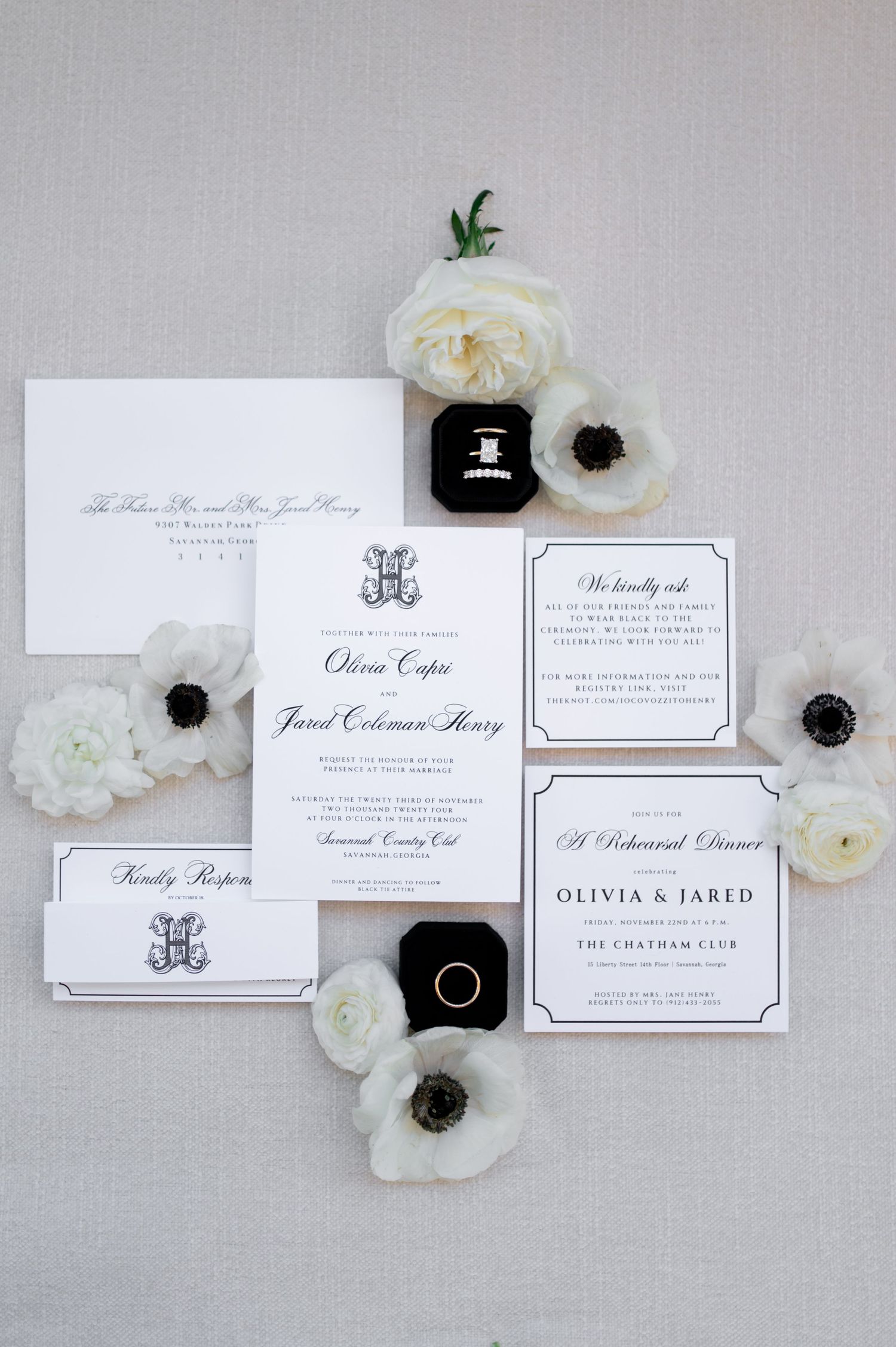 Elegant black and white wedding invitation suite with floral accents.