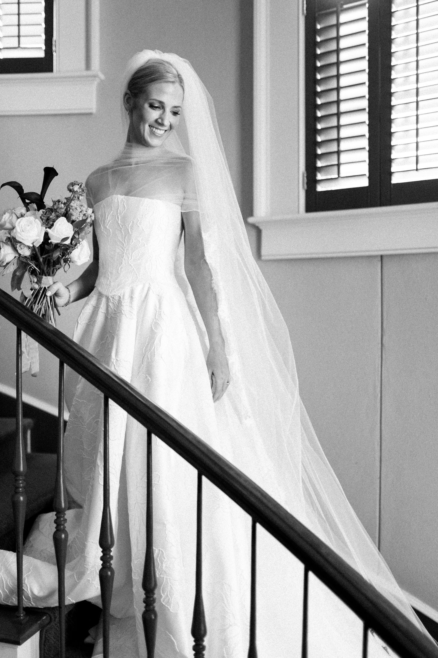 Black and white photos on a staircase showing the movement of a flowing wedding dress.
