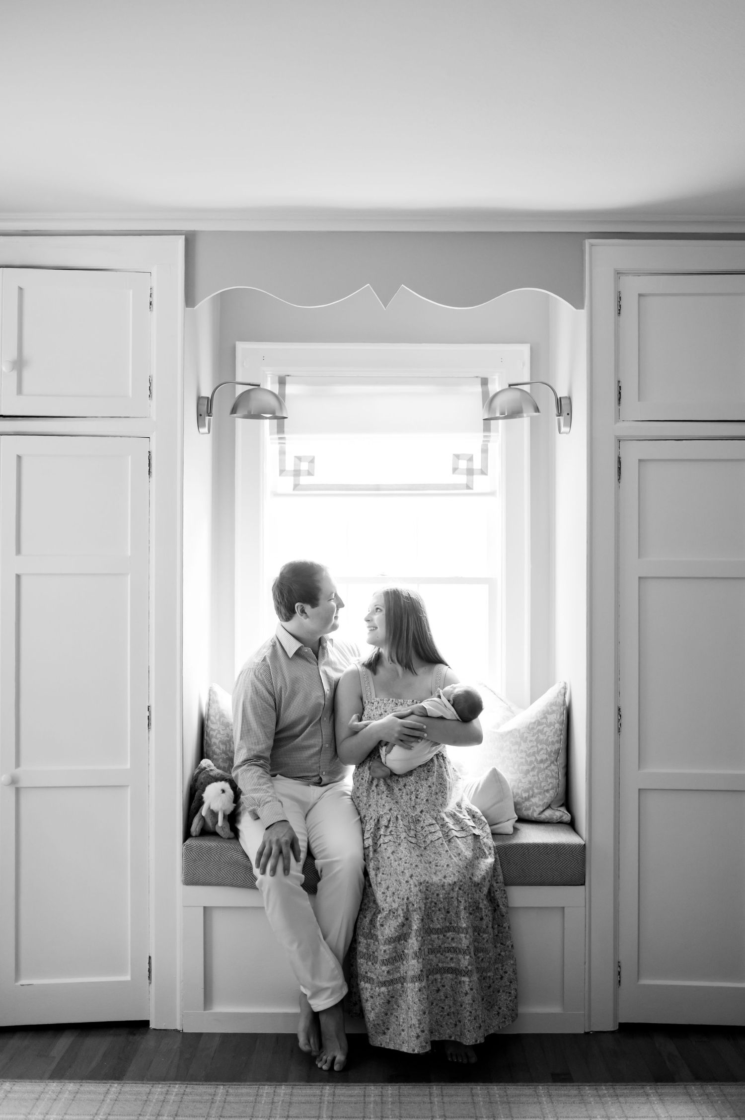 Black and white images showing tender moments between a couple sitting together in a bright interior space.