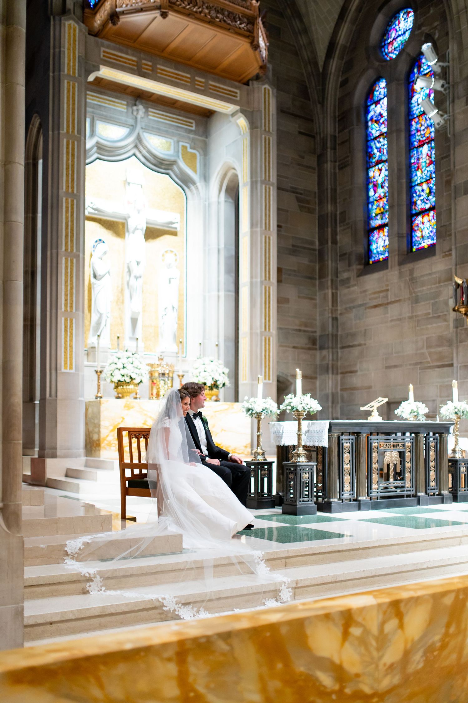 Interior of a grand cathedral with stained glass windows and ornate stone architecture.