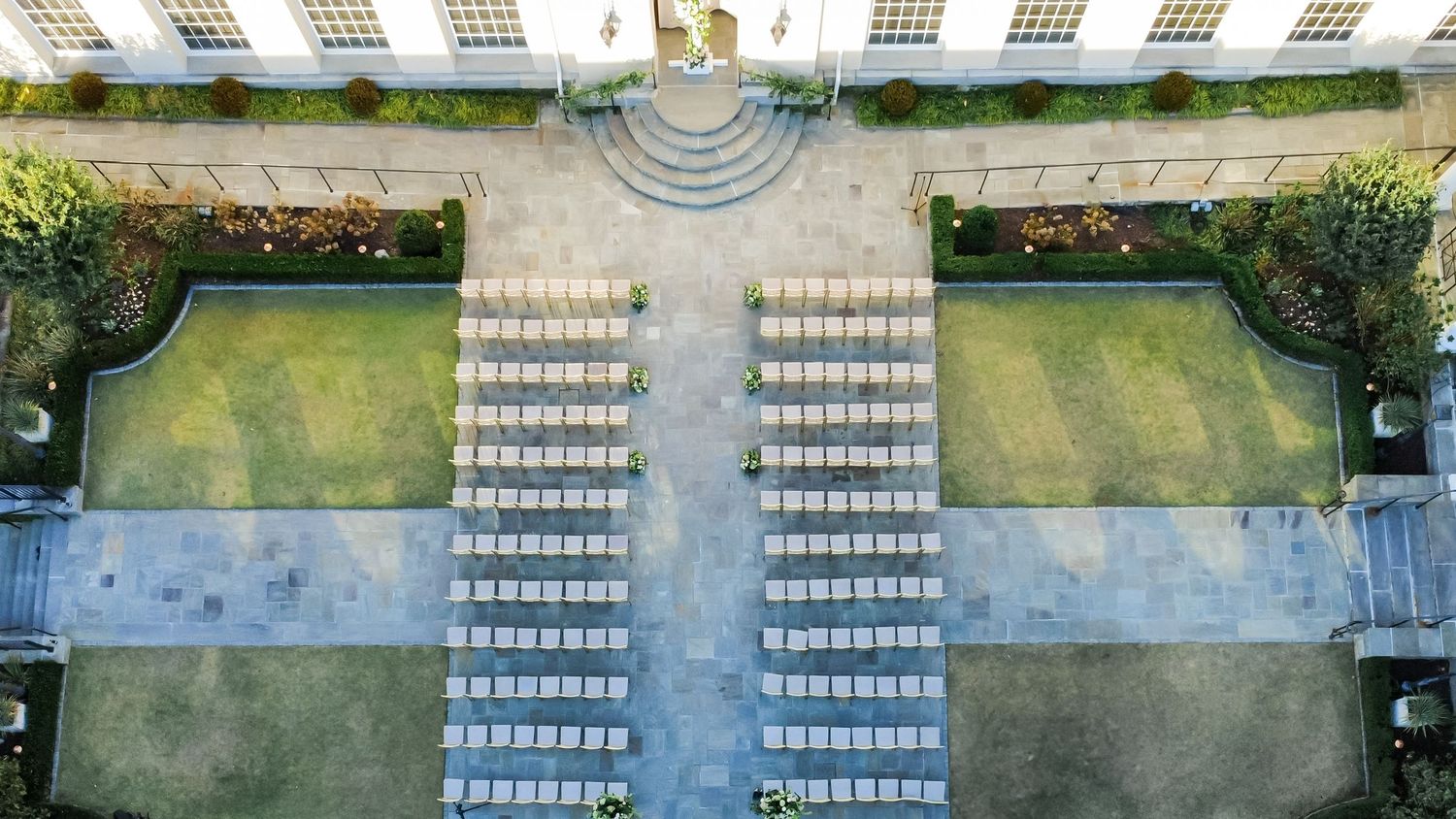 Aerial view of outdoor seating arrangements with white chairs in symmetrical rows.