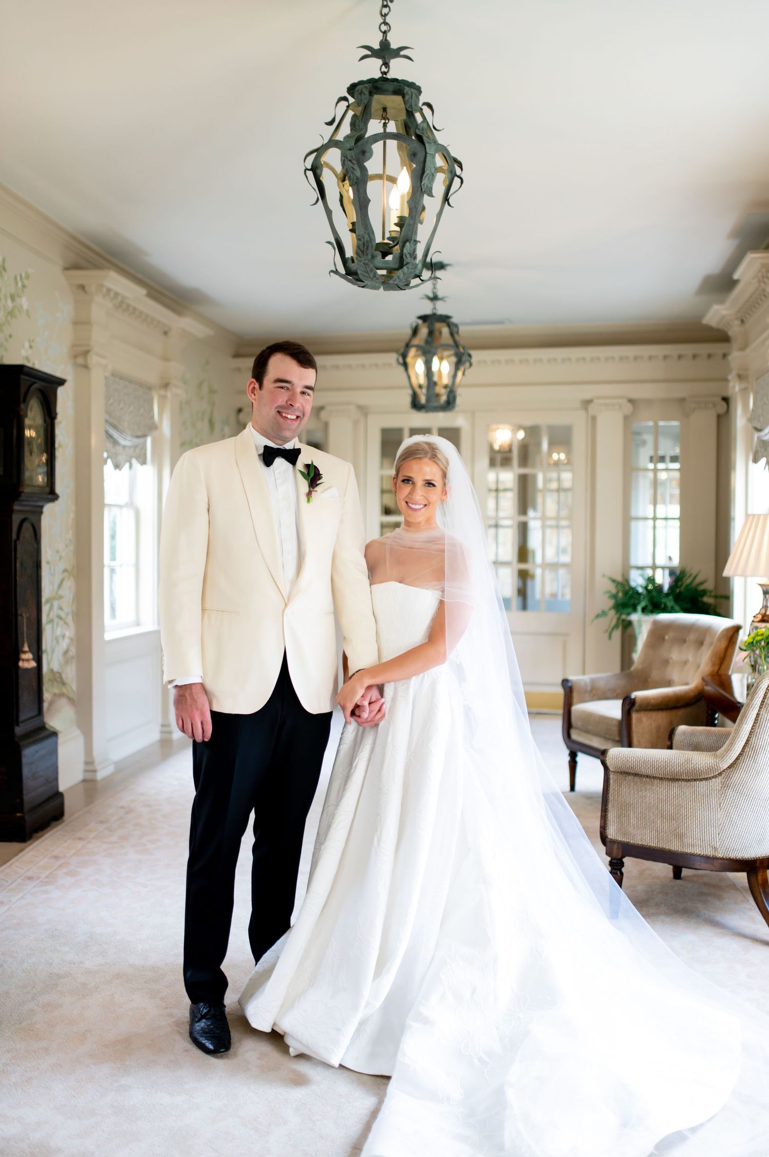 Wedding photos in an elegant room with ornate lanterns and classic white decor.
