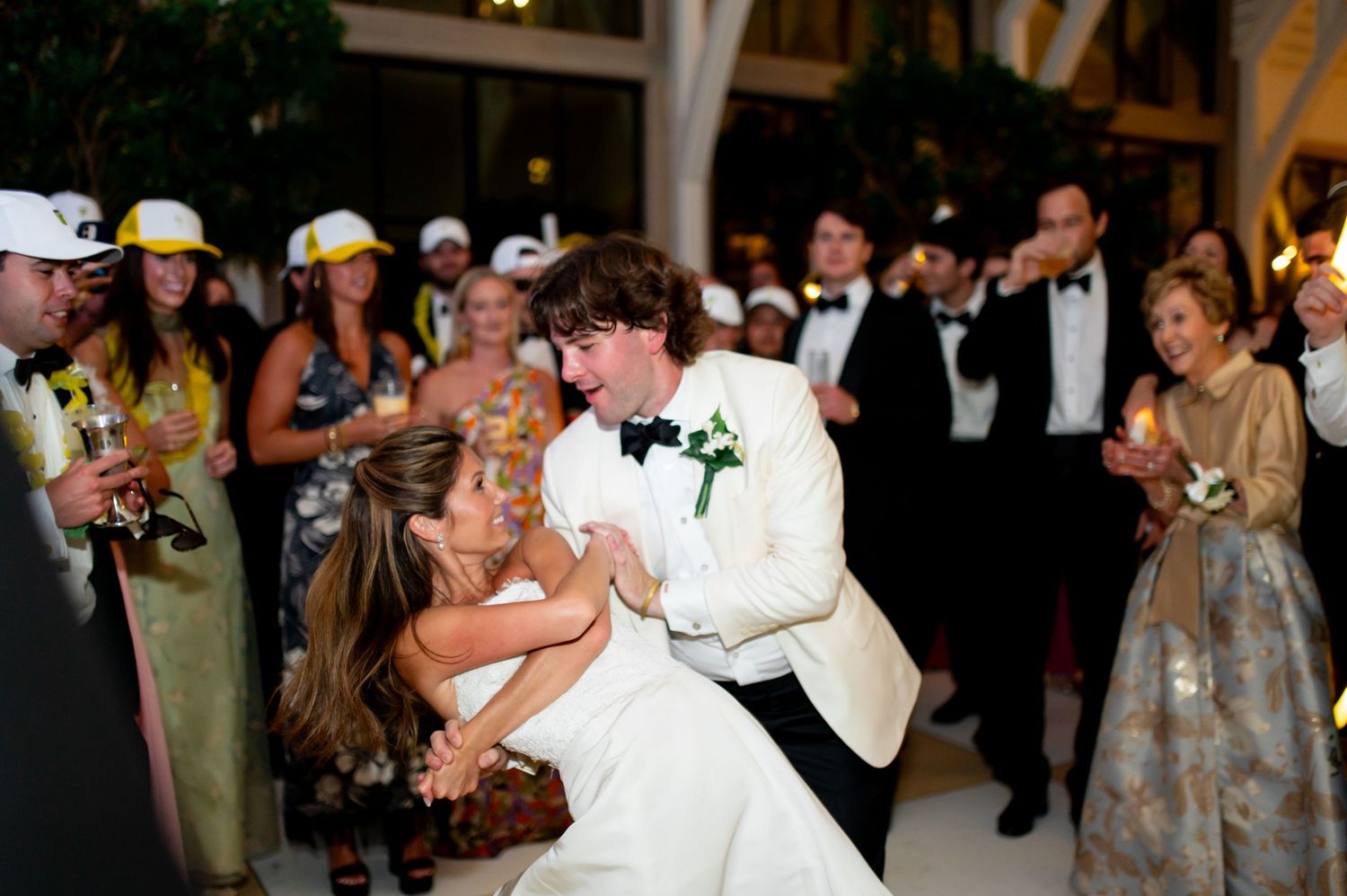 Wedding reception dance floor filled with celebrating guests in formal attire.