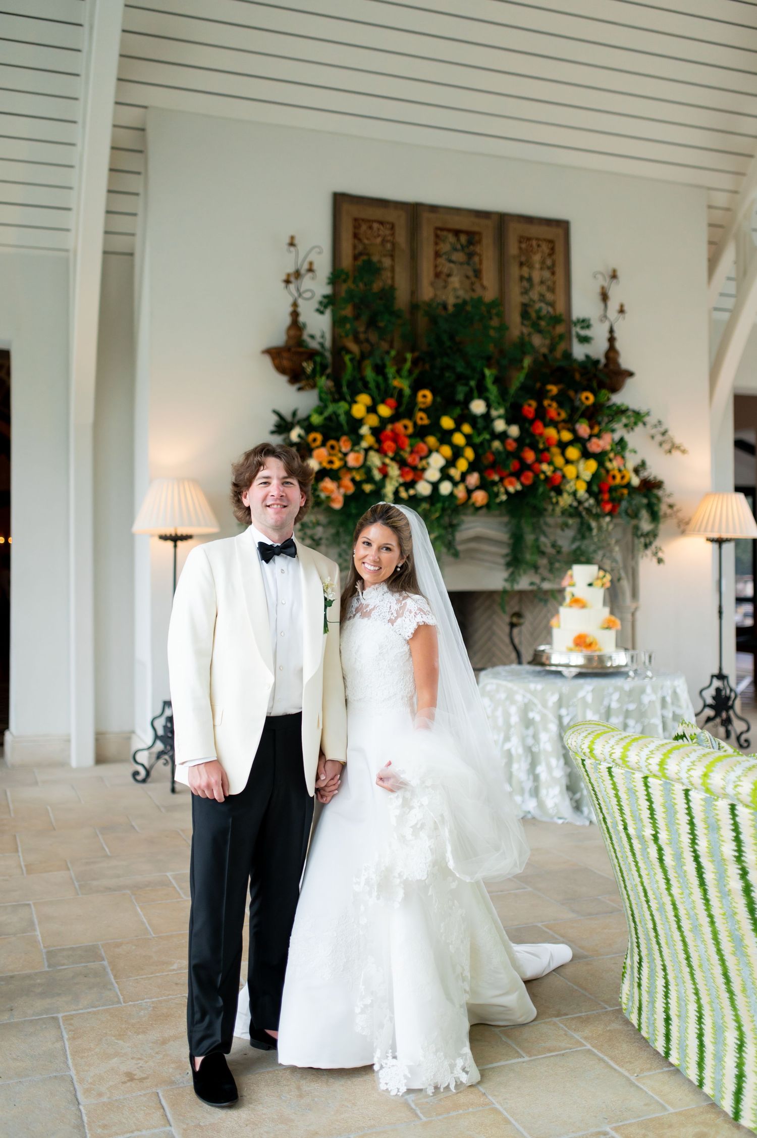 Reception area with green striped chairs and floral arrangements against white walls.