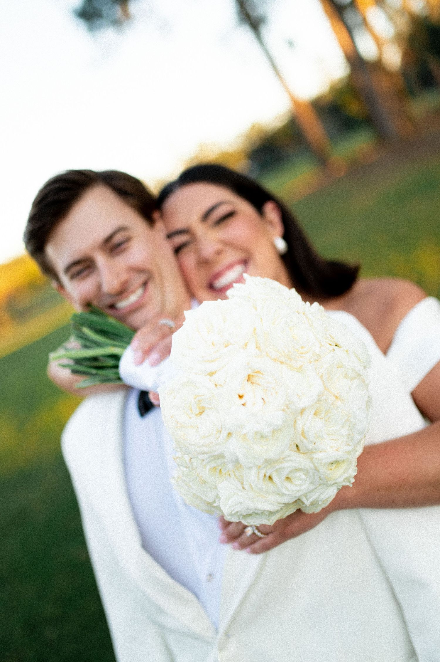Candid wedding moments with white rose bouquet and formal attire.