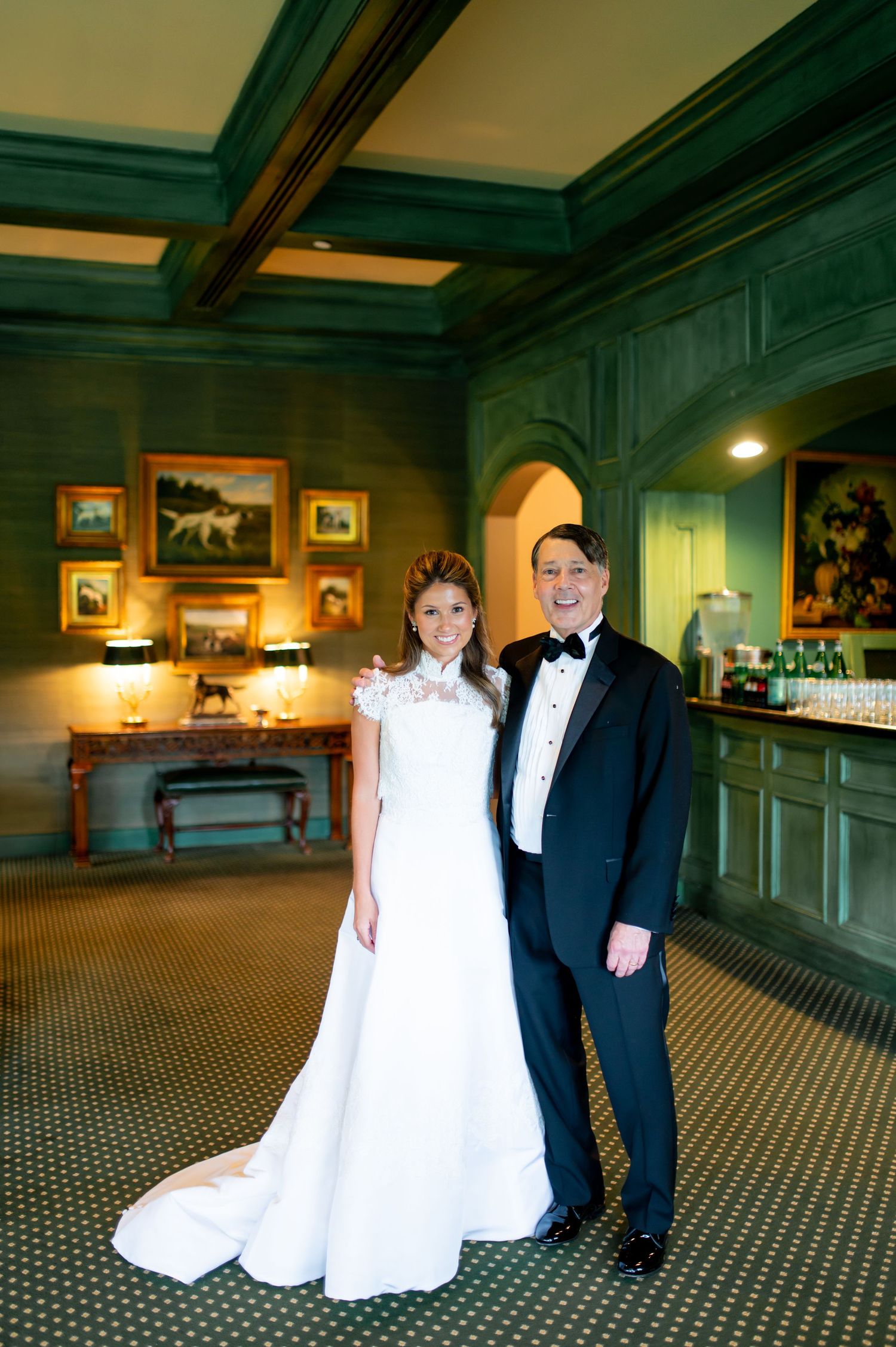 Wedding couple poses in elegant wood-paneled room with vintage decor and checkered floor.
