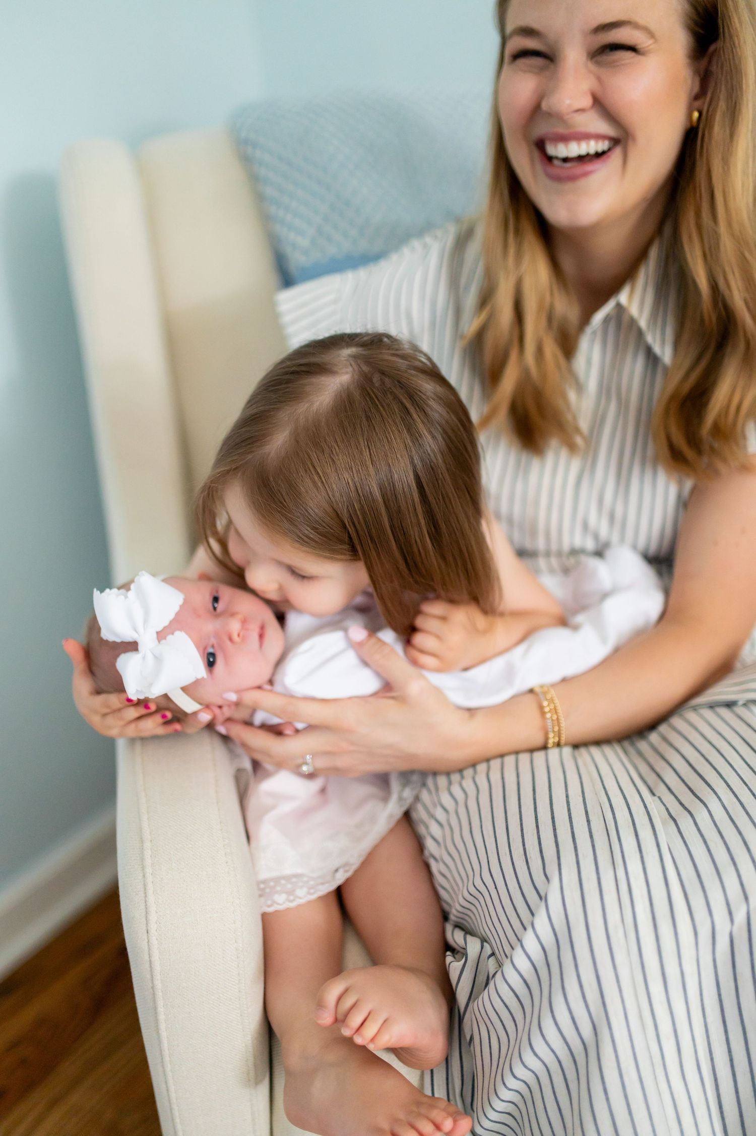 Tender moments captured between parent and baby in a bright nursery setting.