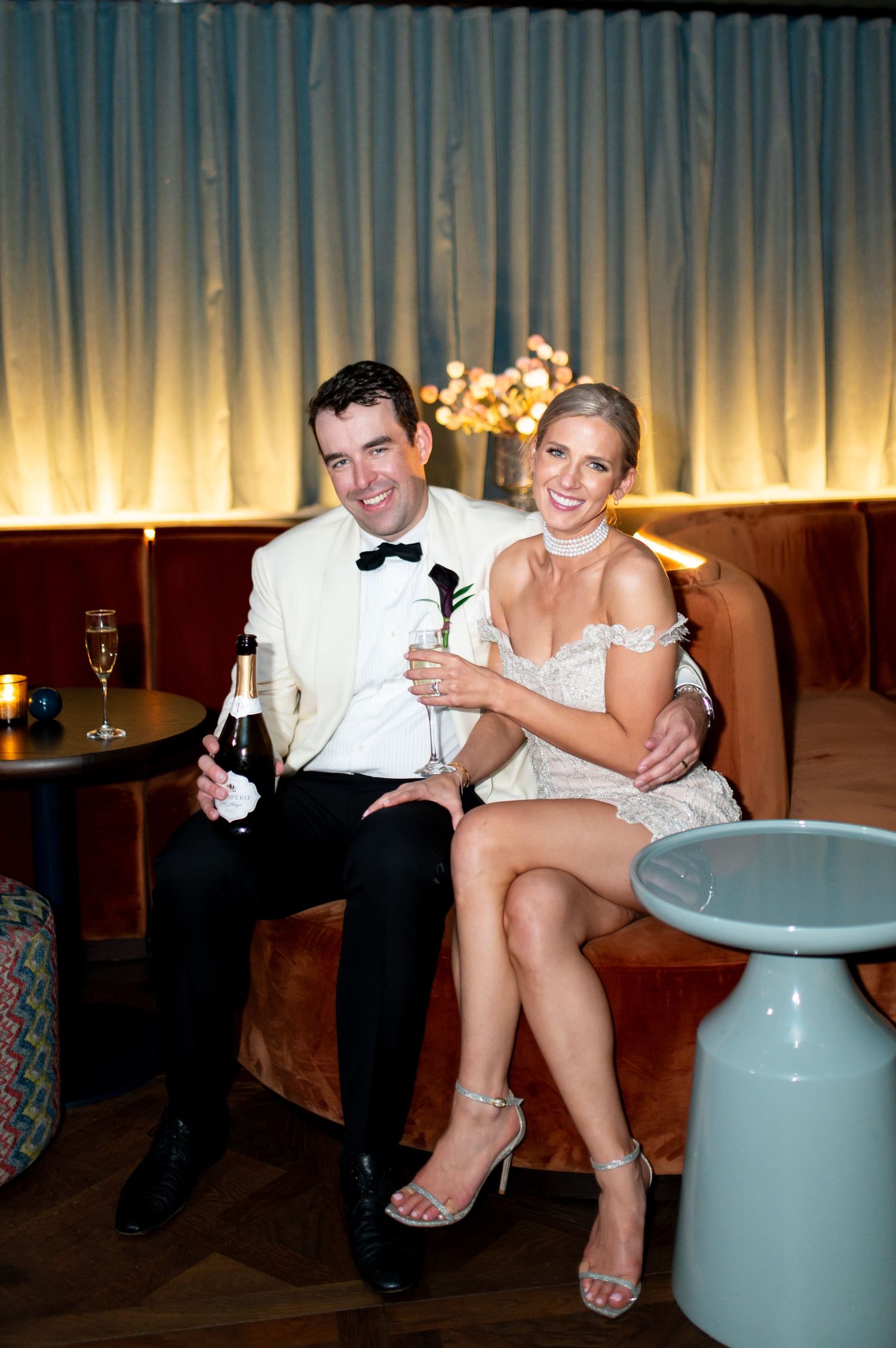 Couple relaxing on modern furniture at an elegant reception venue with mood lighting.