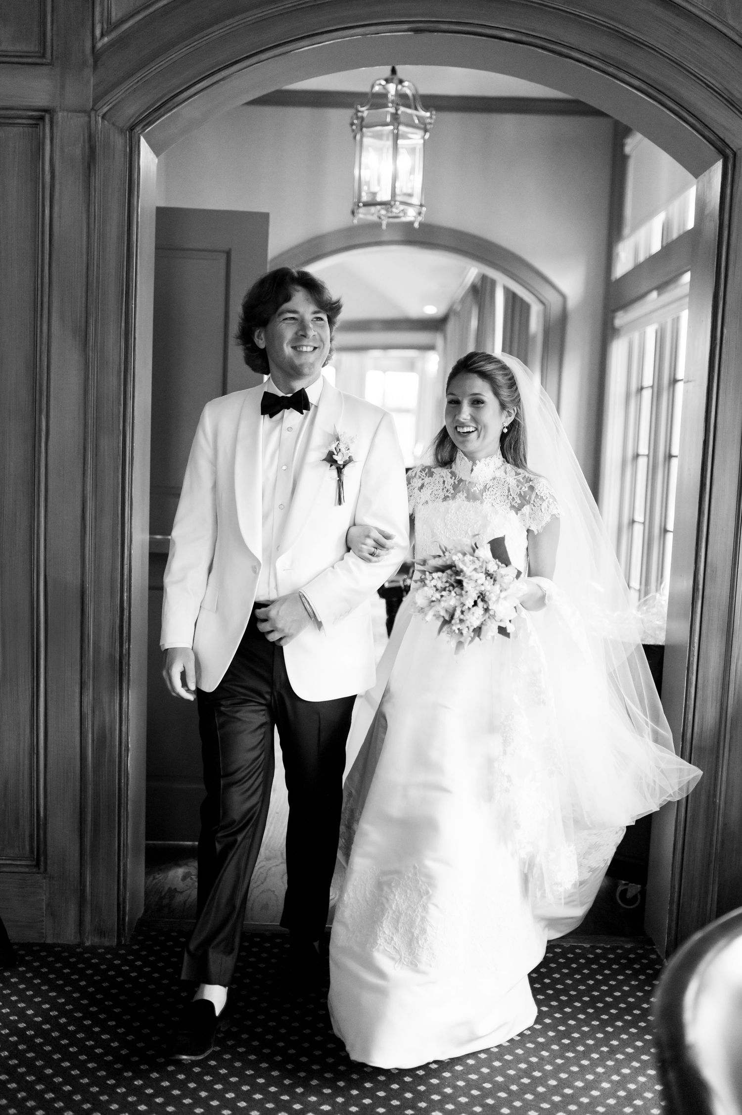 Black and white wedding sequence showing couple walking through arched hallway.