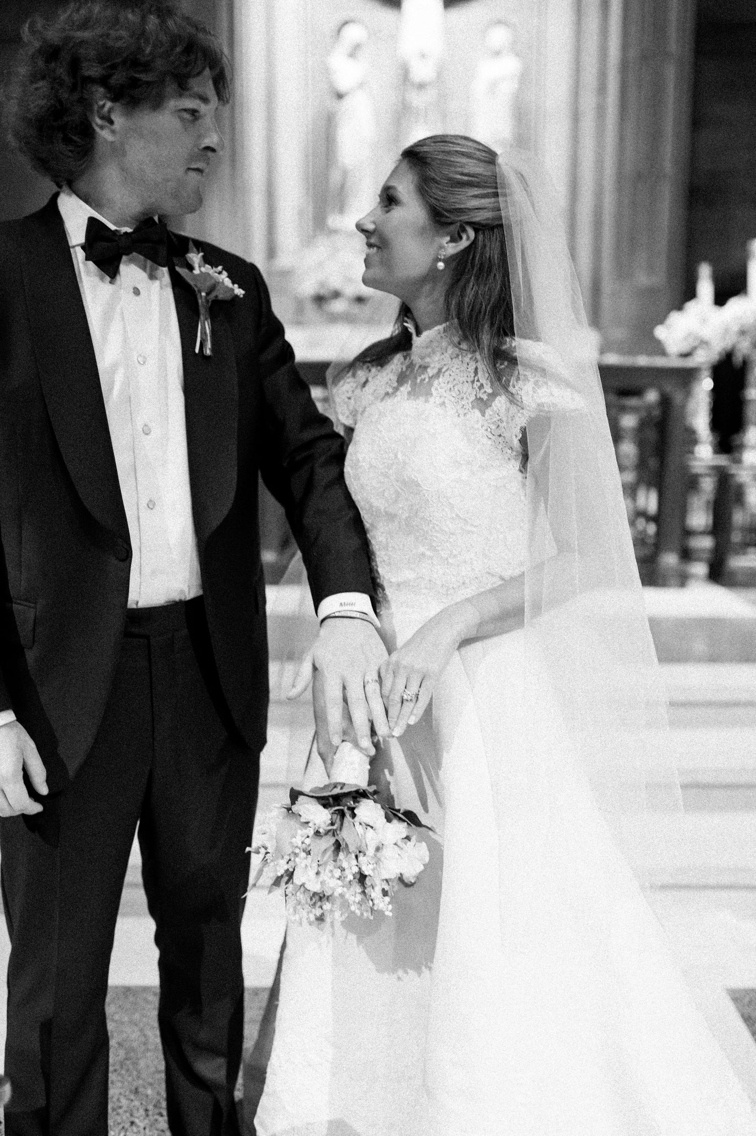 Elegant wedding couple in formal attire sharing intimate moments in a cathedral setting.