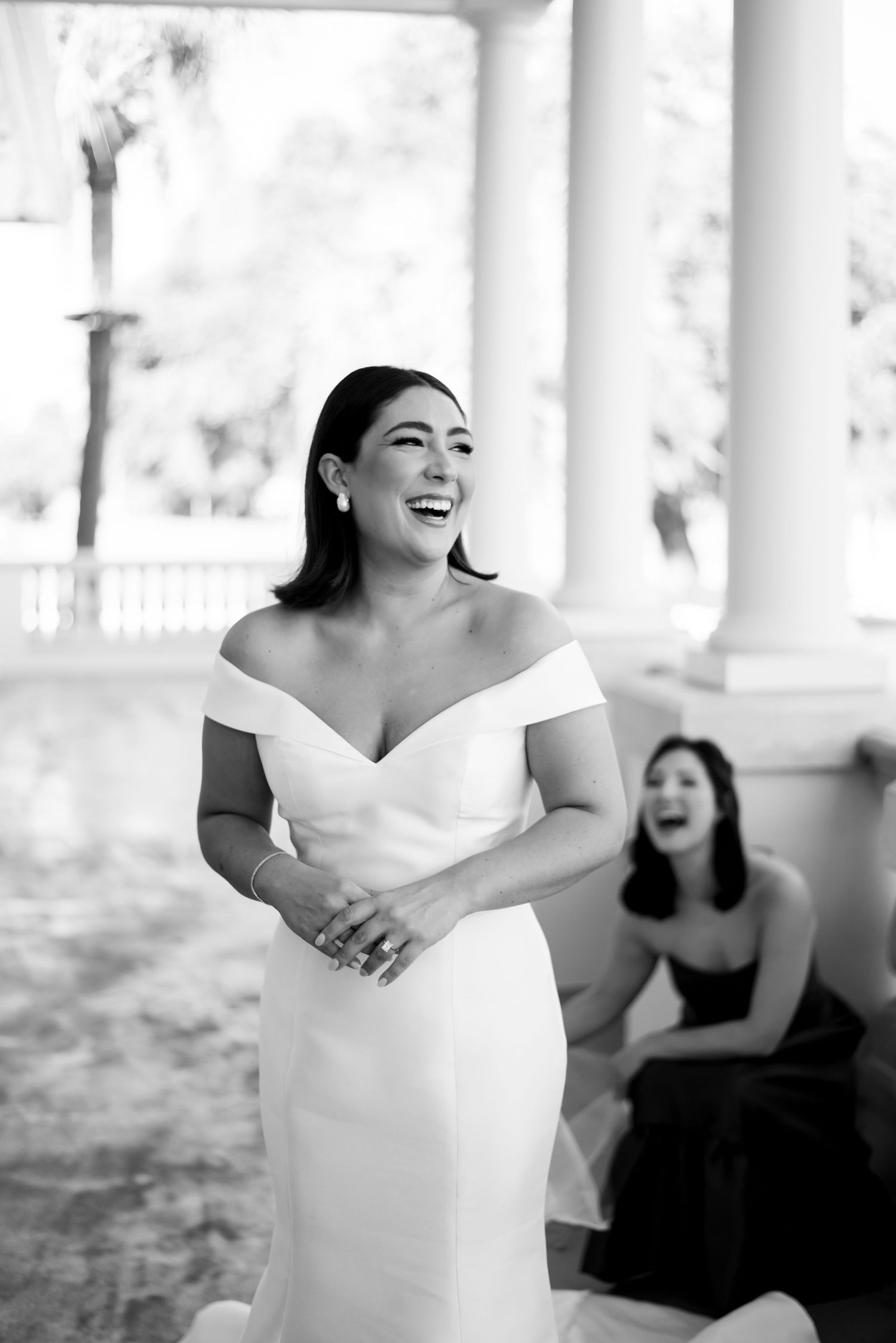 Joyful wedding celebration with people laughing in black and white attire.