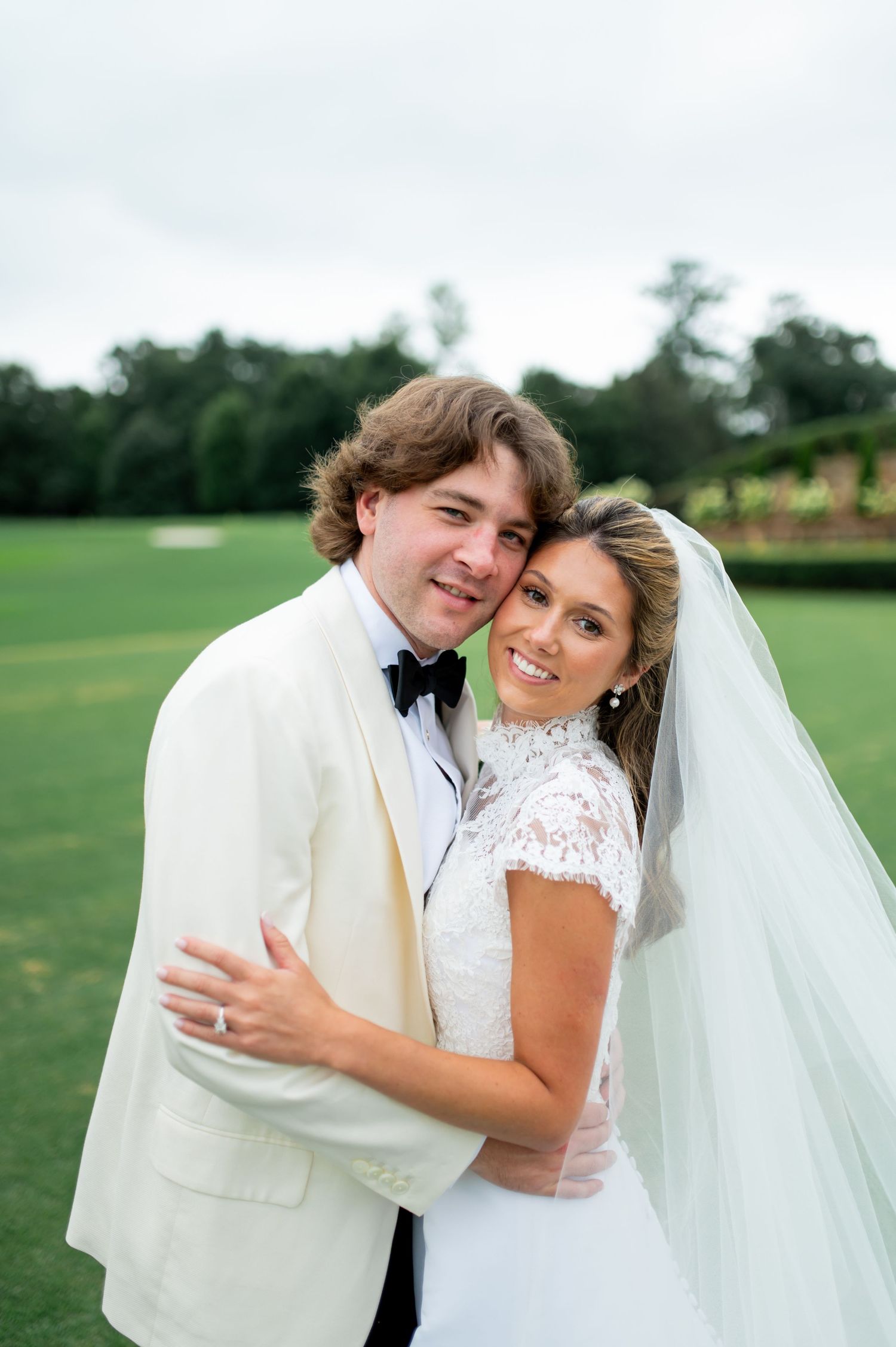 Intimate wedding portrait captured on a lush green golf course.