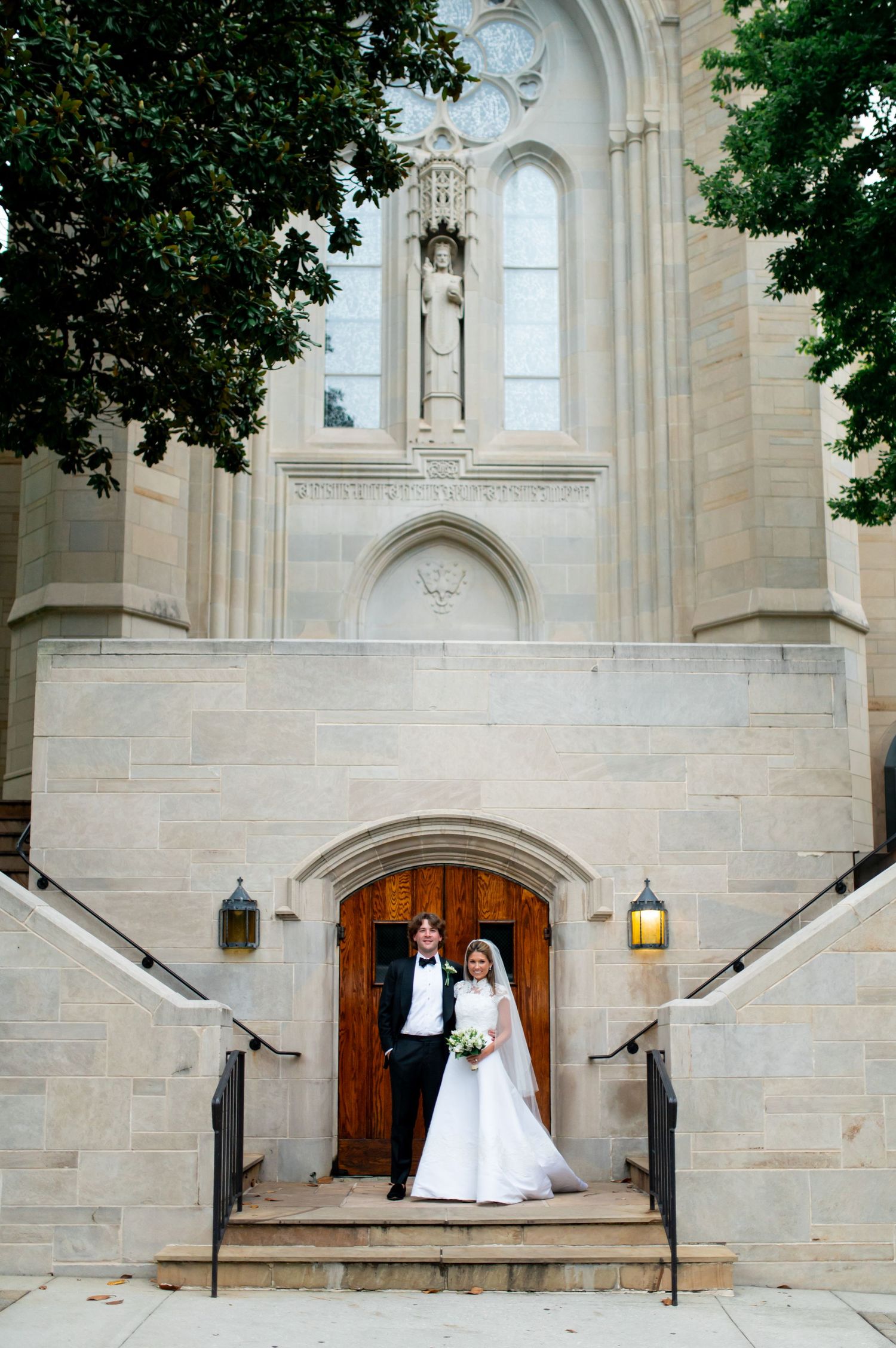 Elegant church entrance serves as backdrop for wedding photography session.