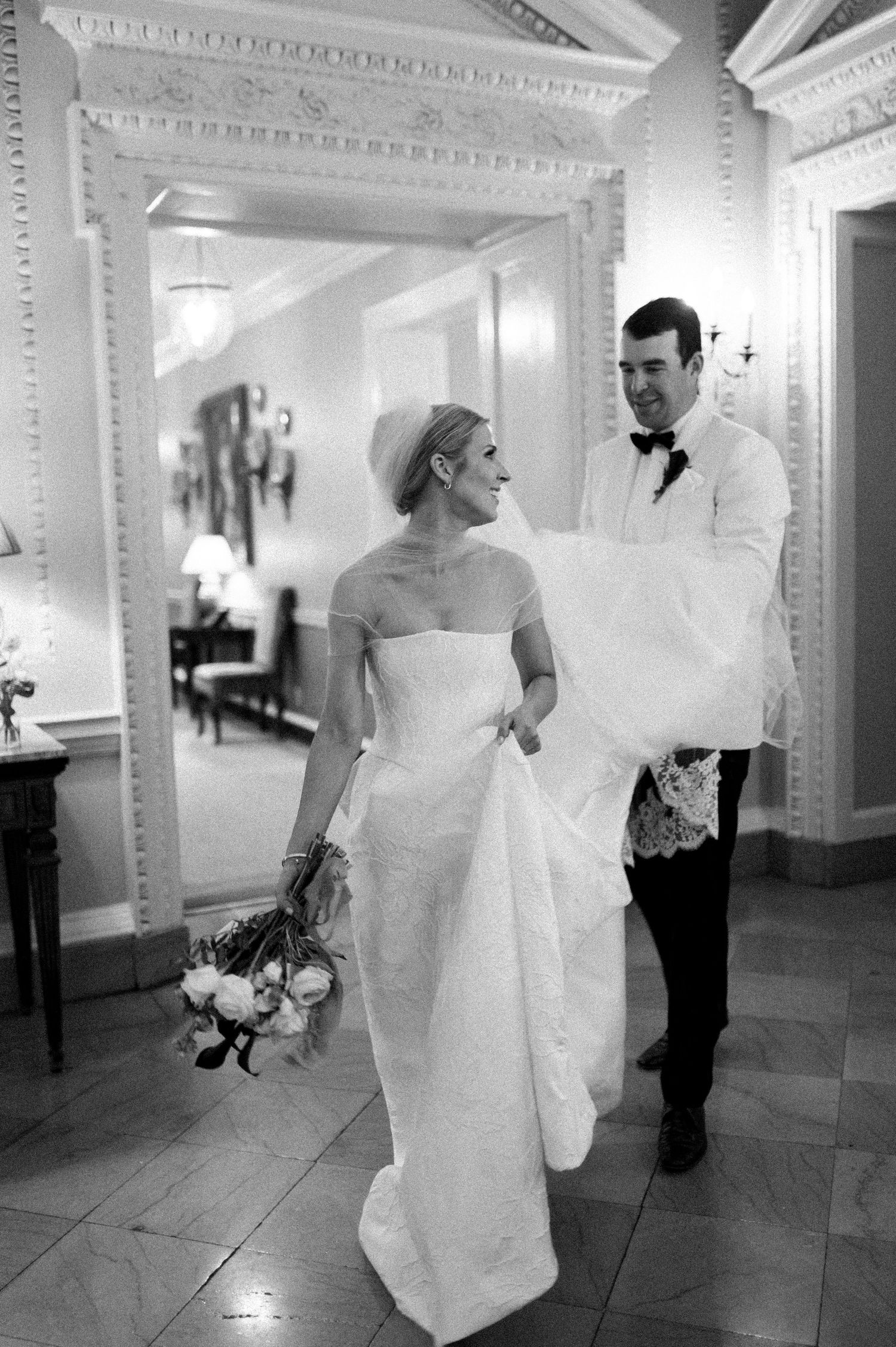 Black and white series of wedding photos showing couple walking through elegant interior hallway.