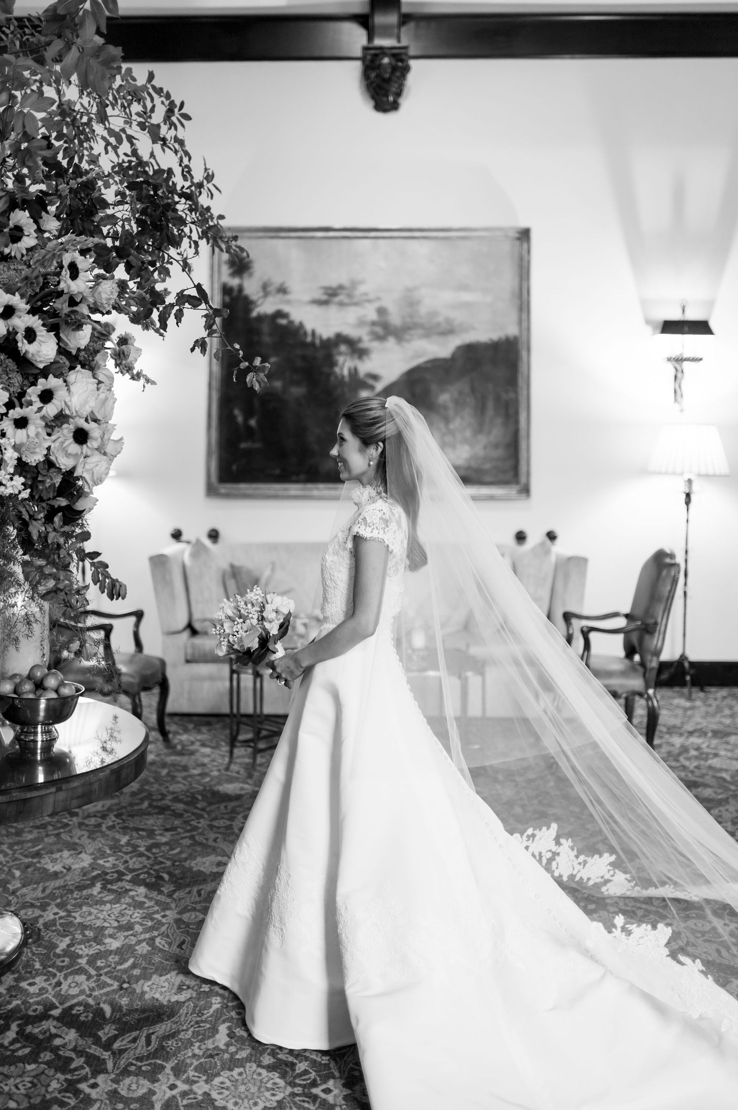 Classic wedding dress with cathedral veil photographed in an elegant interior setting.