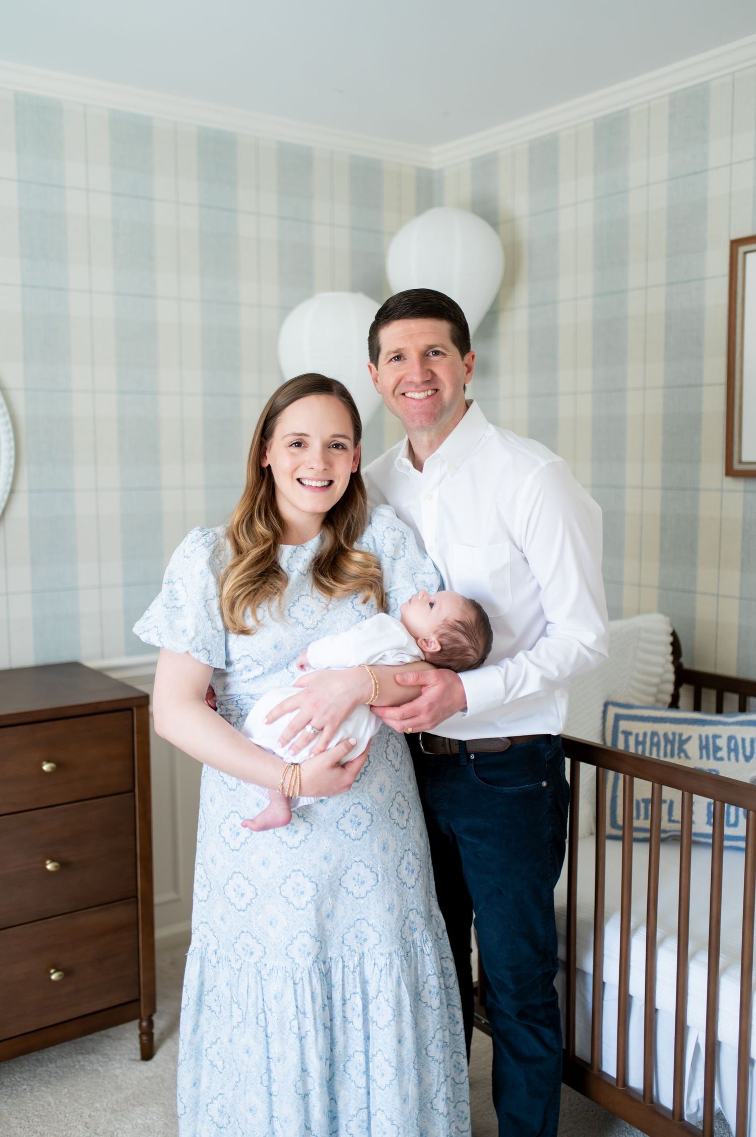 A series of intimate family portraits showing tender moments in a nursery room with light blue striped wallpaper.