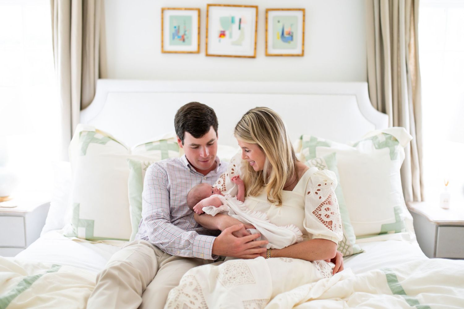 Intimate family moments captured in a bright, neutral-toned bedroom.