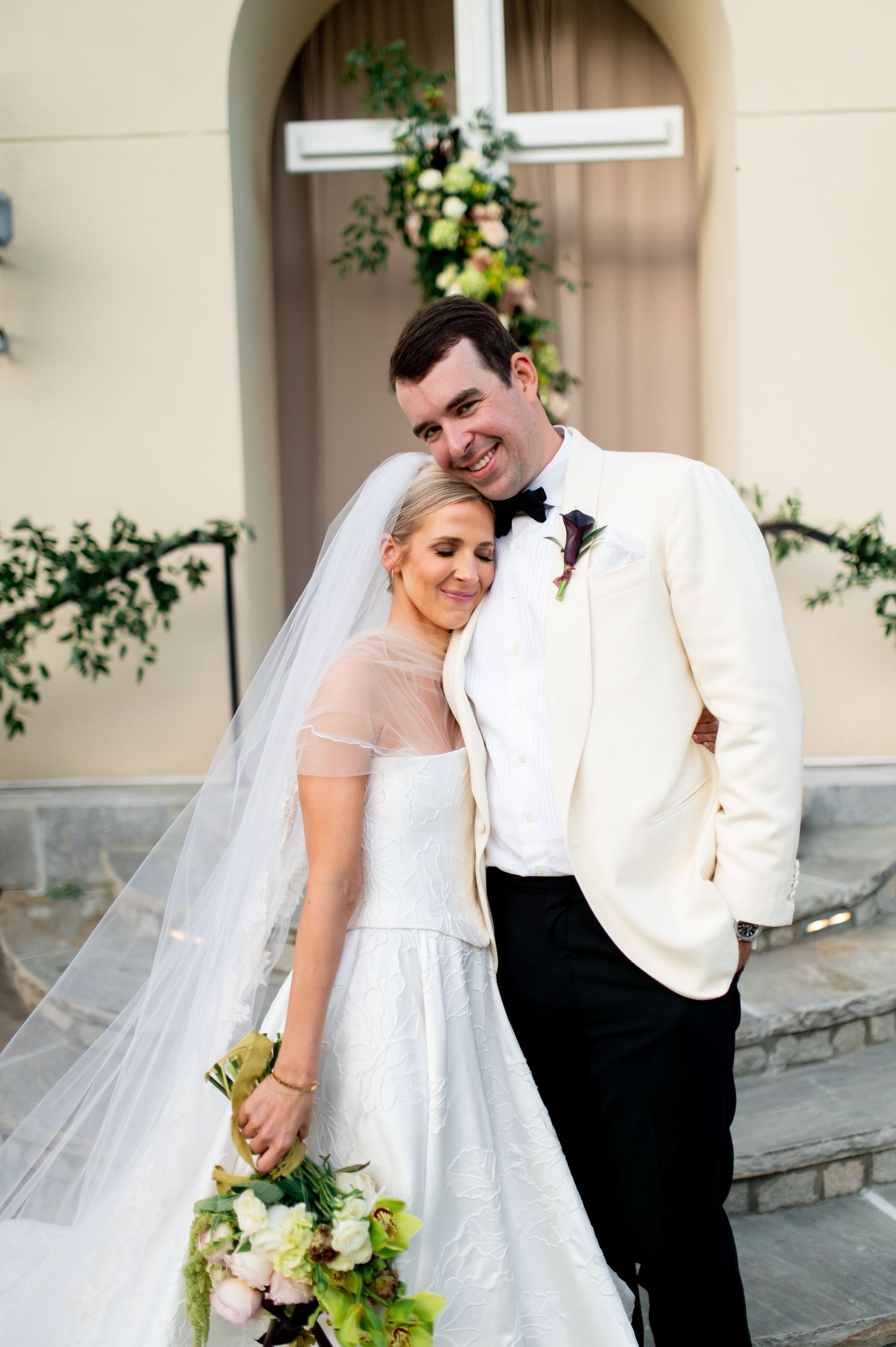 Candid wedding portraits captured against architectural backdrop with hanging lanterns.