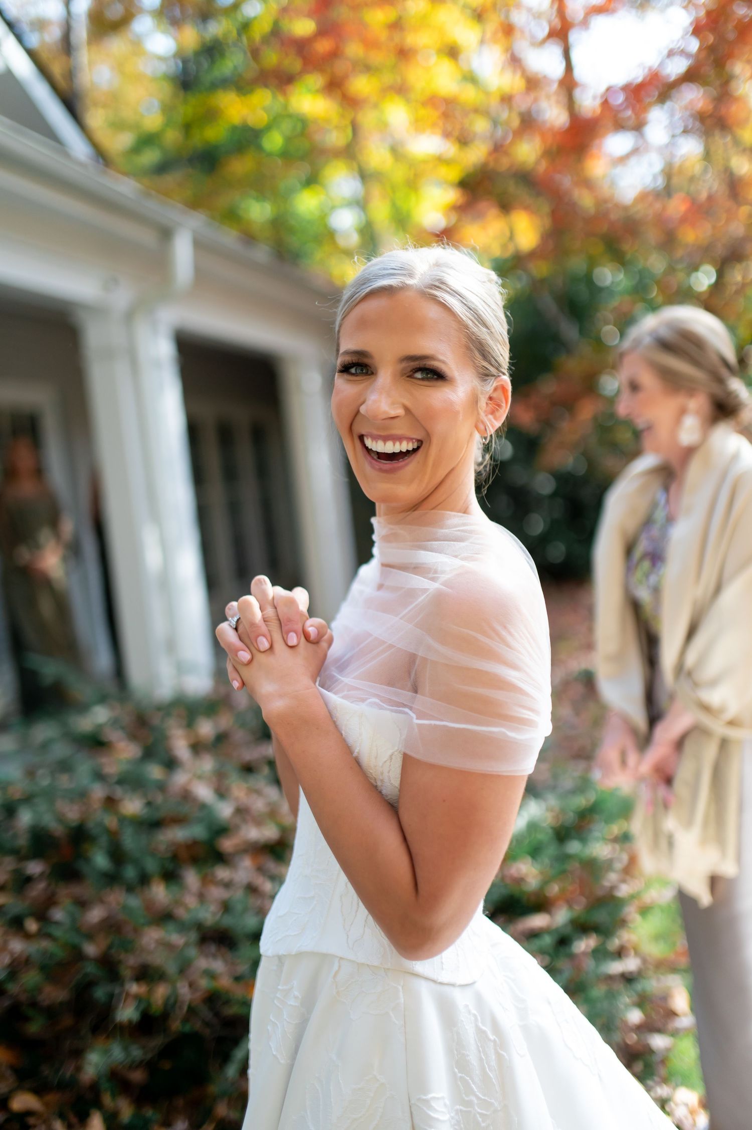 Candid moment of joy captured during autumn wedding preparations.