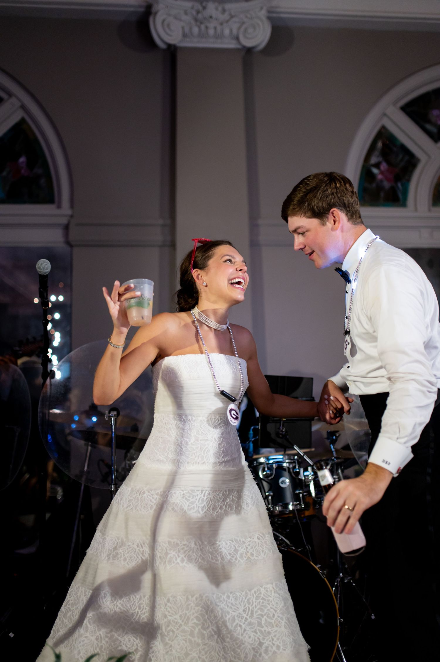 Bride and groom laughing together on the dance floor during their wedding reception celebration.