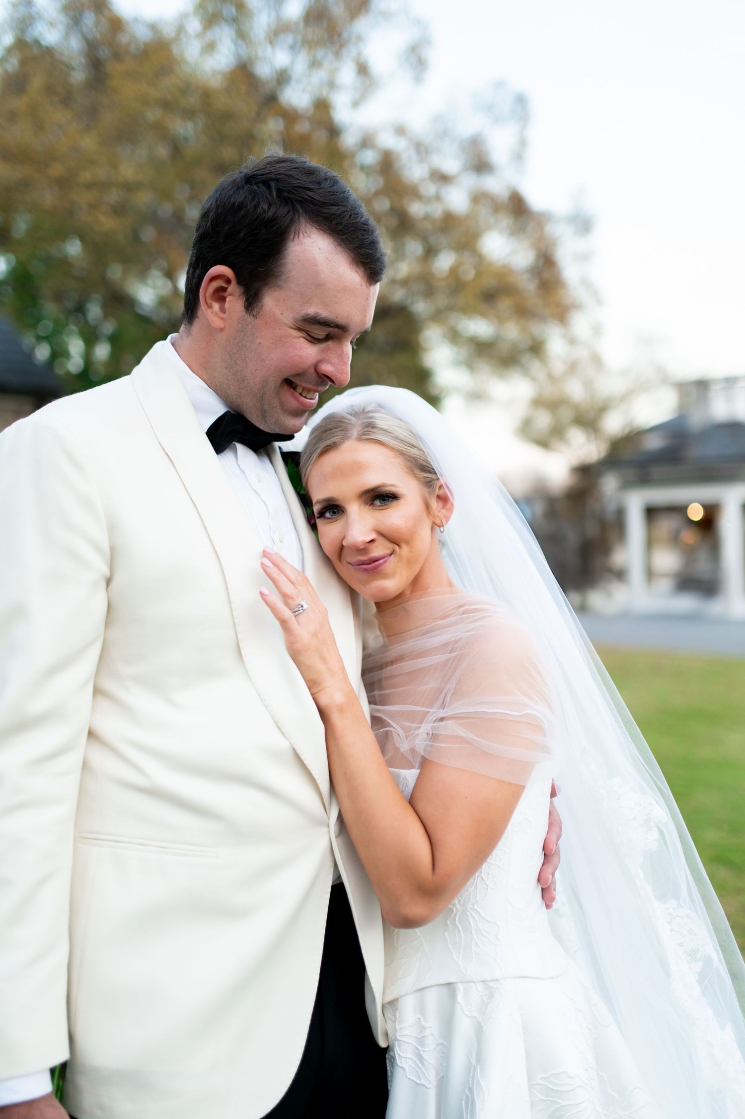 Intimate wedding portraits showing couple in white attire against outdoor setting.