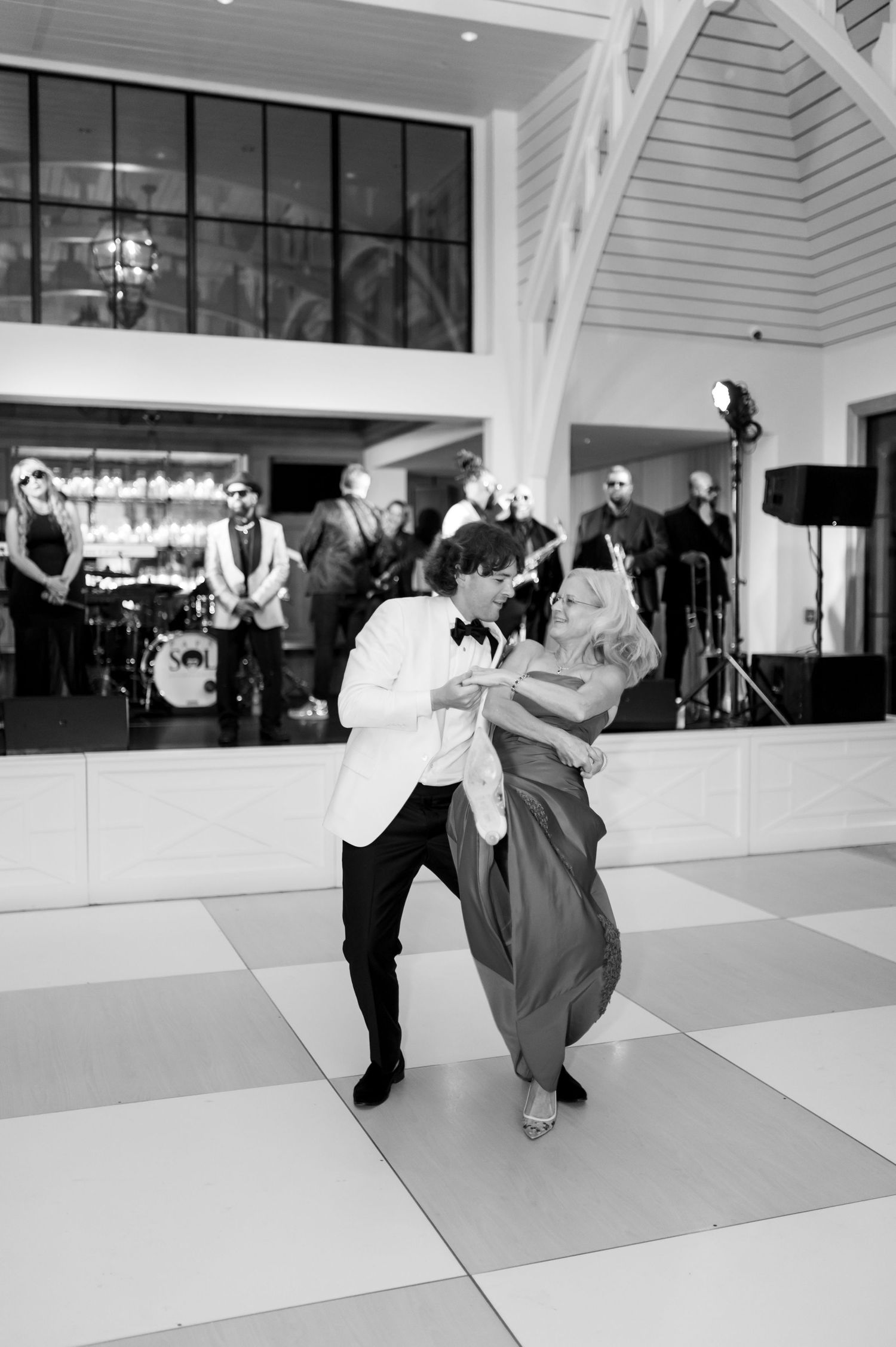 Black and white photo of a wedding dance with a live band performing in the background.