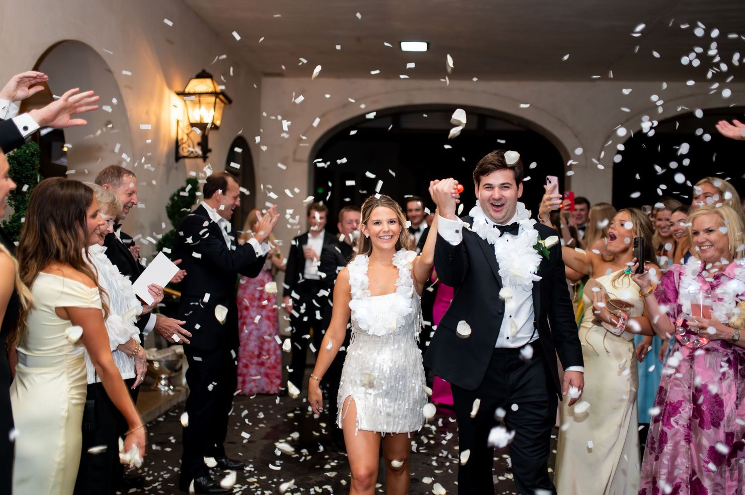Wedding celebration with confetti falling as guests dance and celebrate.