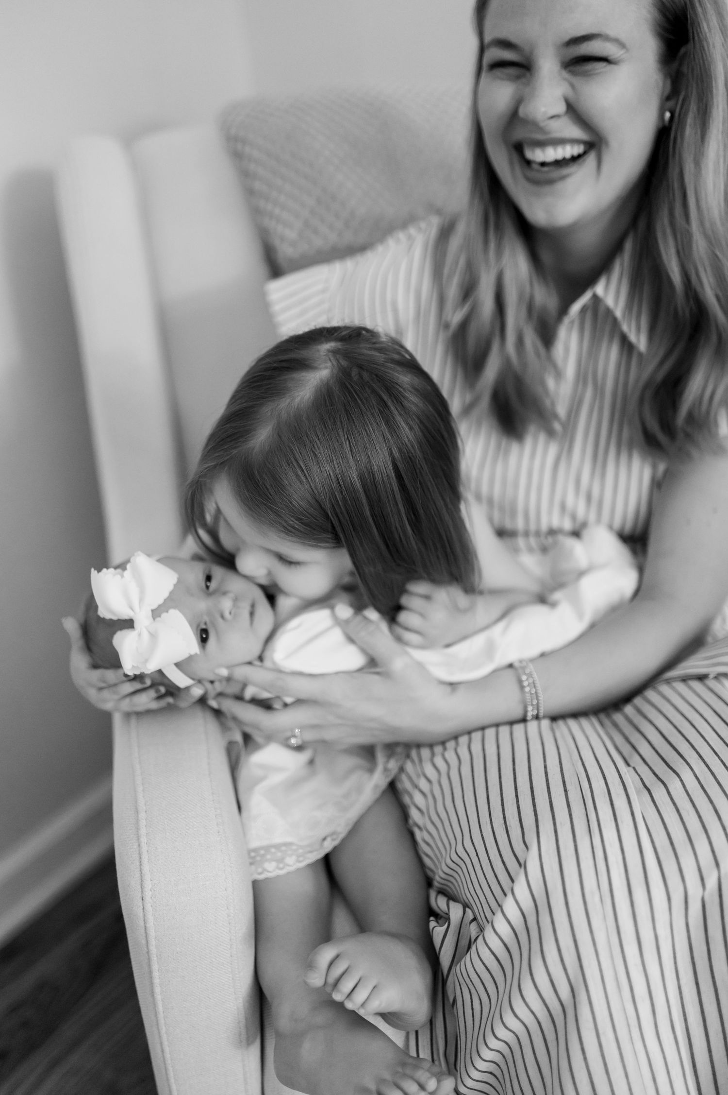 Black and white photo sequence showing tender moments between parent and baby in striped dress.