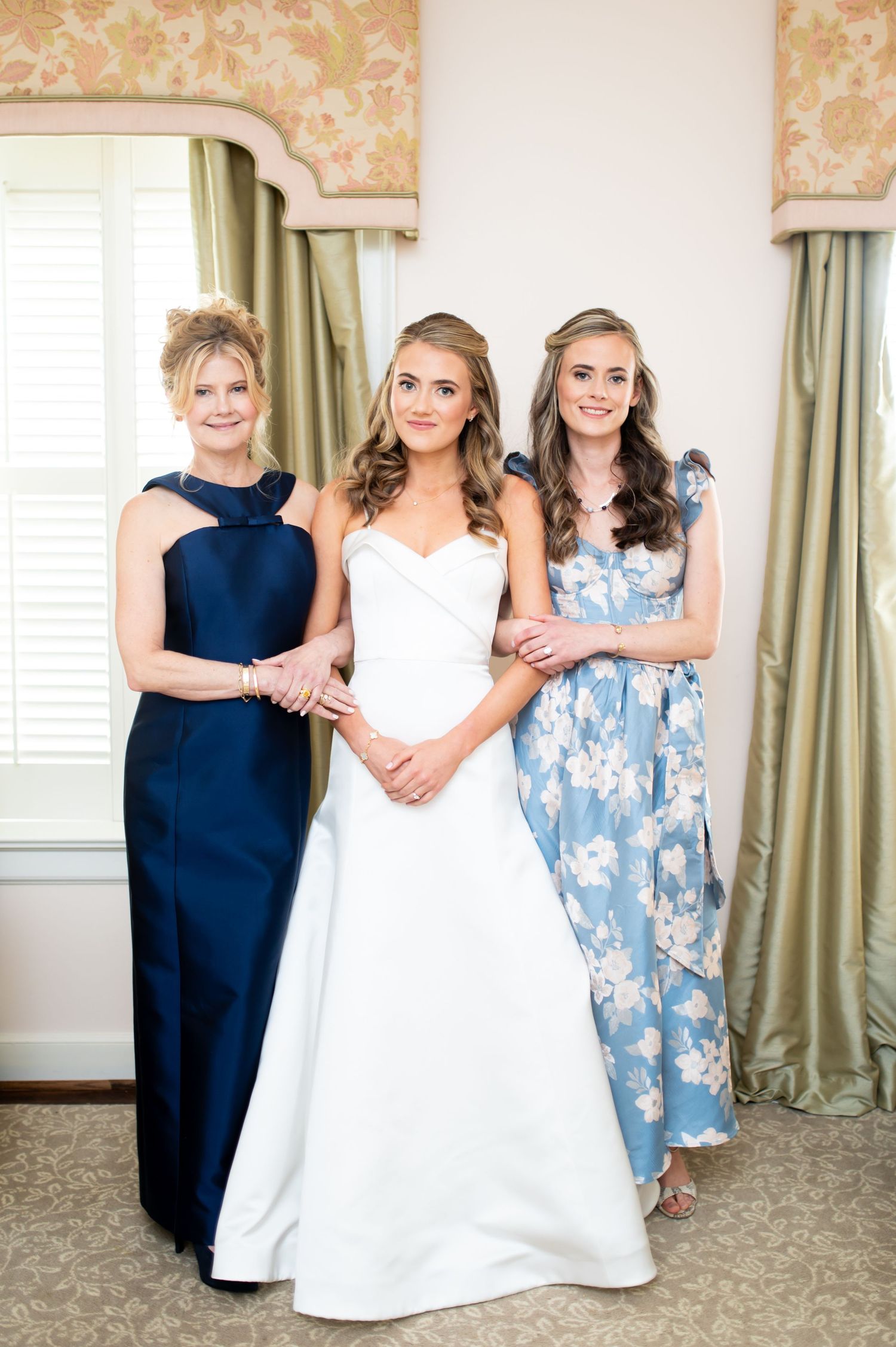 Wedding party poses elegantly in formal attire featuring navy blue and floral dresses.