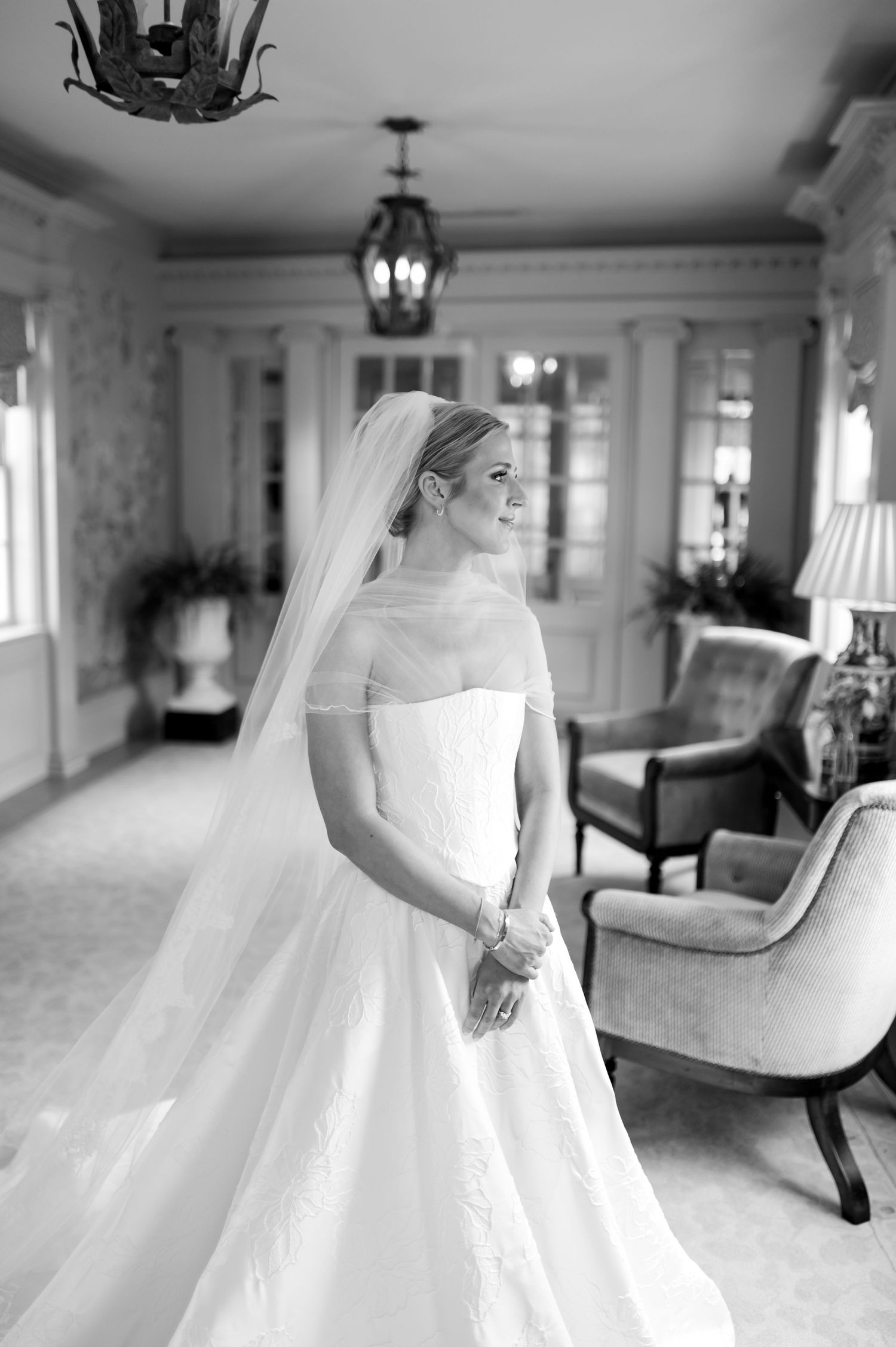 Black and white photos of a bride in a flowing white gown moving through an elegant room.