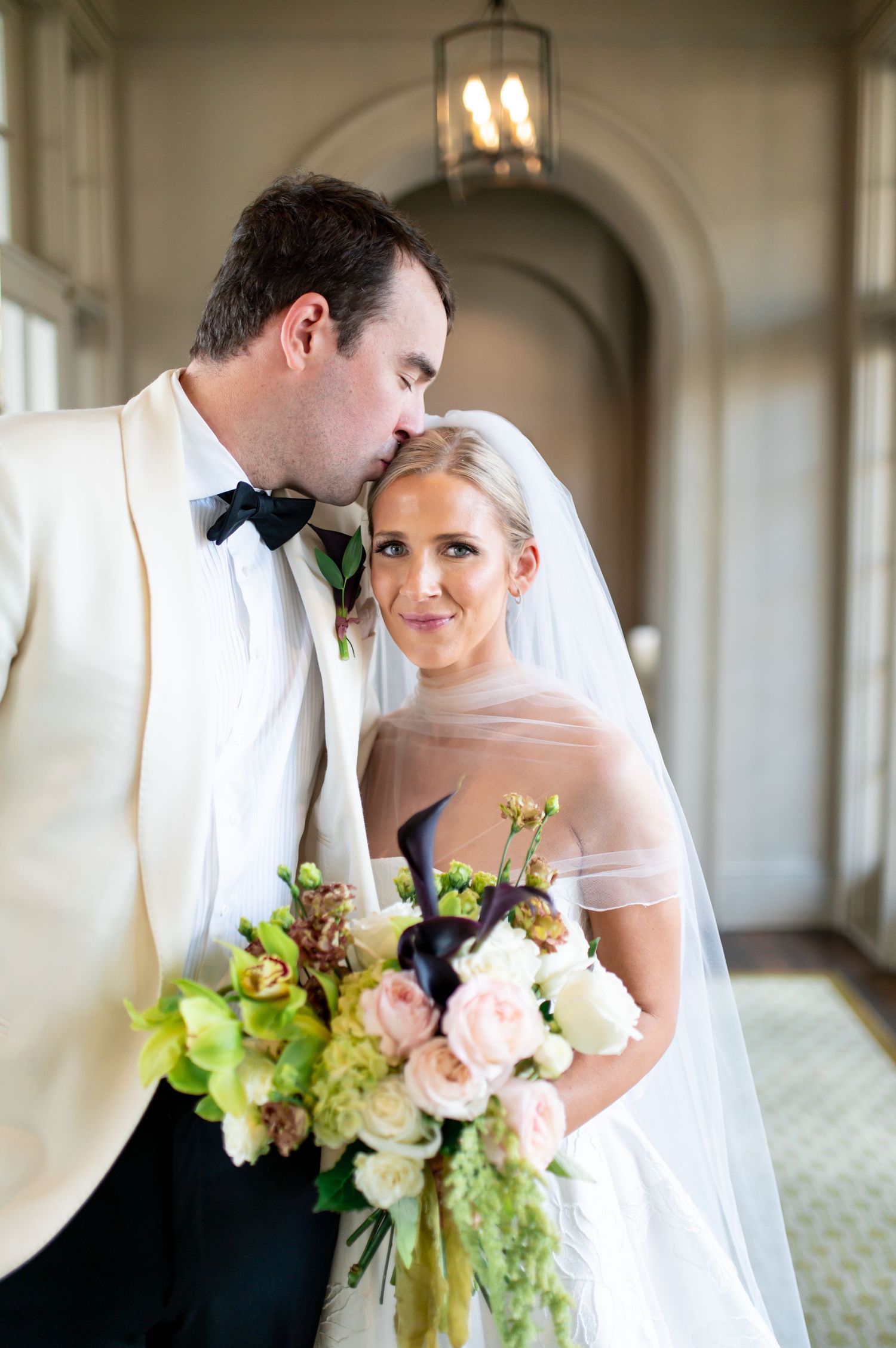 Romantic wedding portraits captured in an elegant hallway with arched architecture.