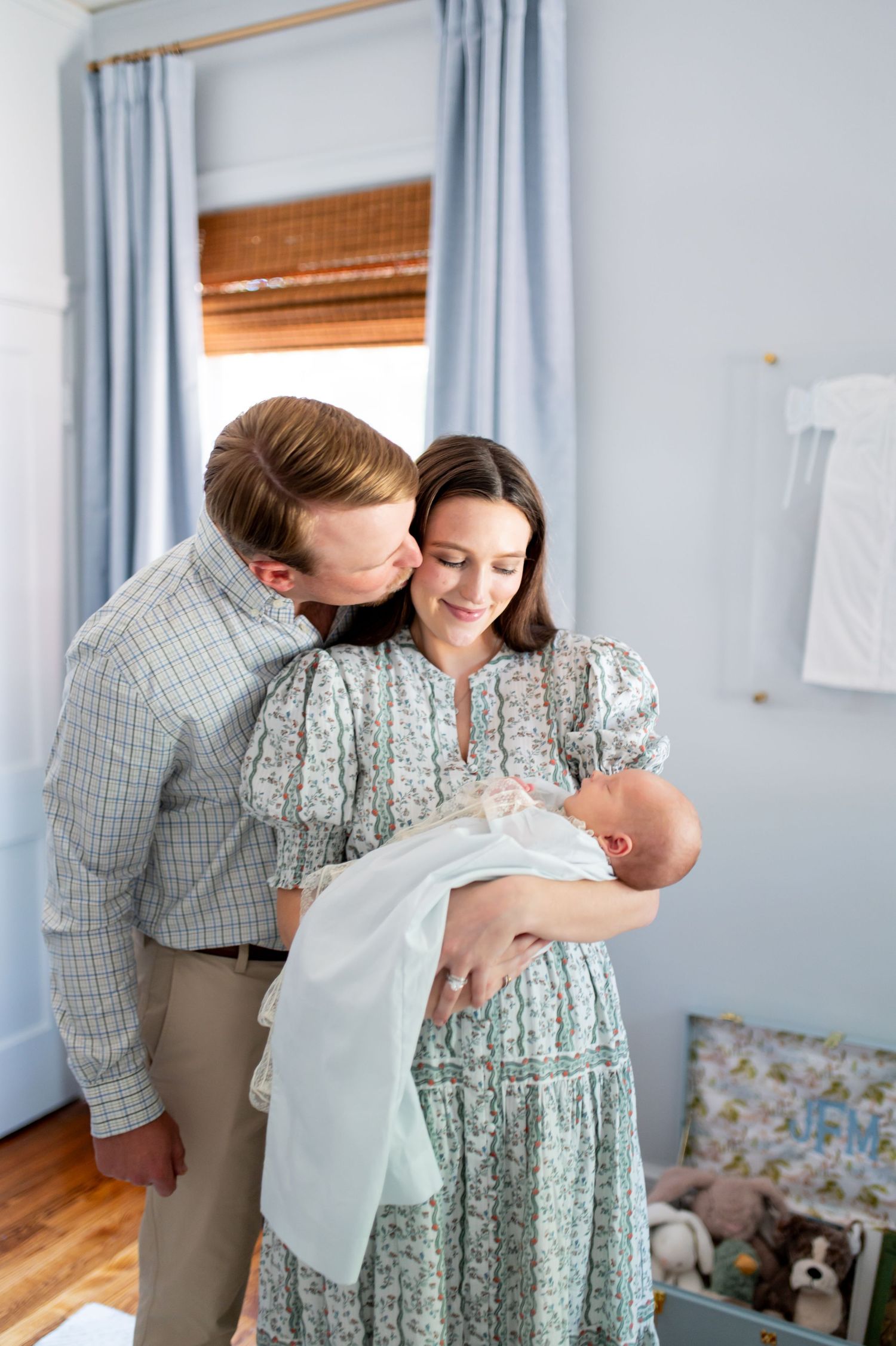 Intimate family moments captured in a blue-walled nursery with natural light.