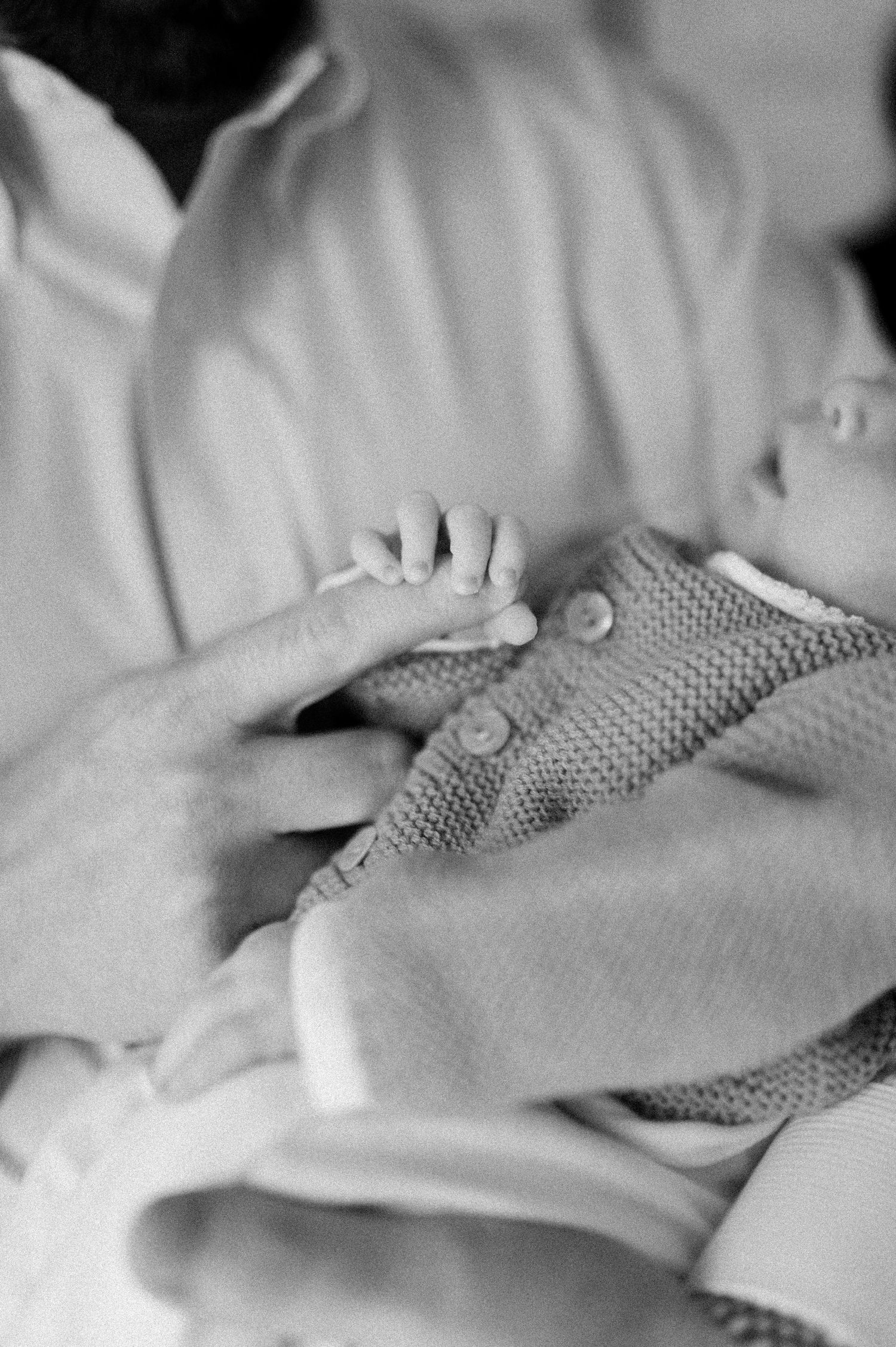 A close-up sequence of hands massaging and manipulating a textured surface in black and white.