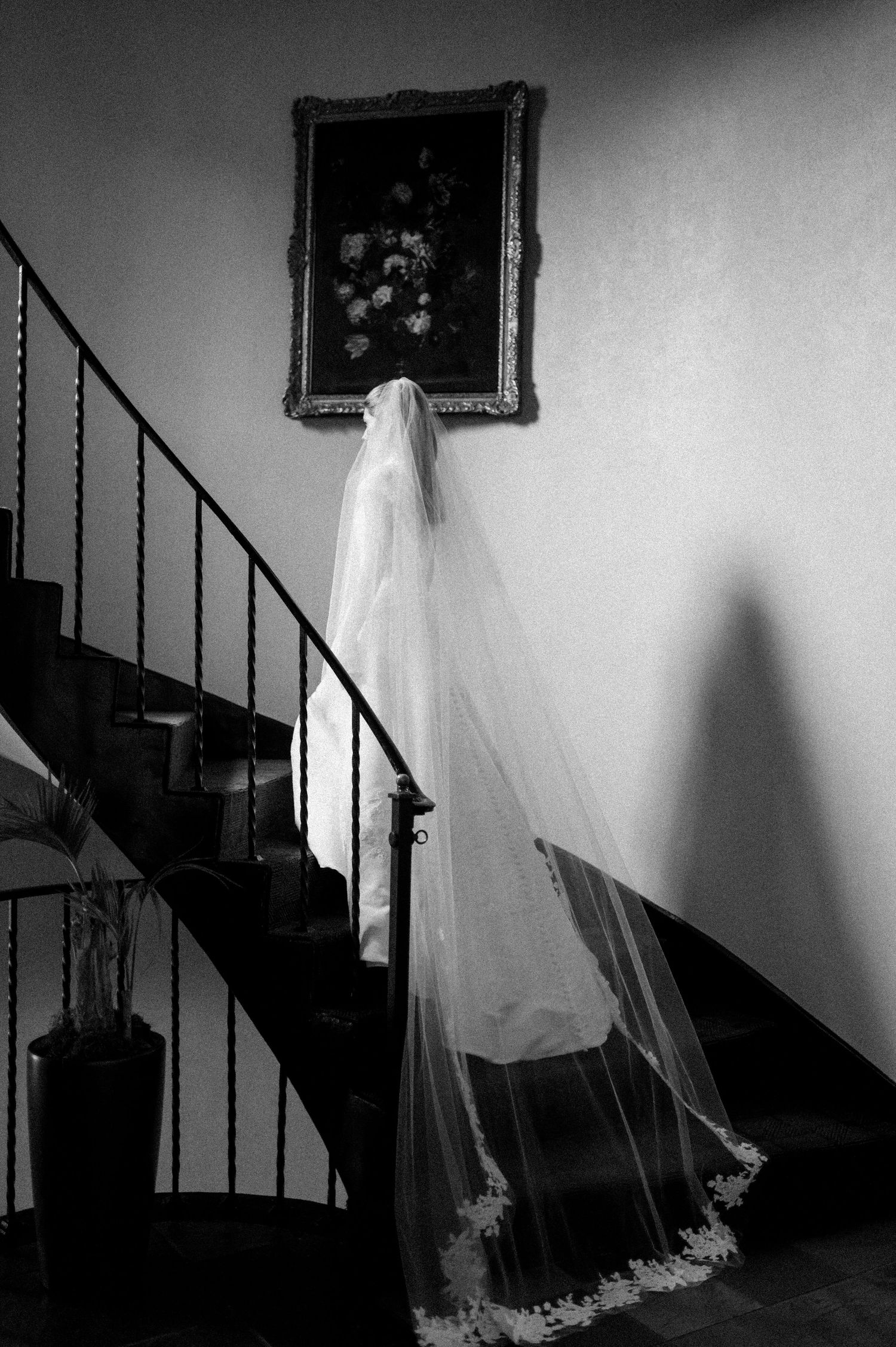 Artistic black and white photos of a wedding dress creating shadows on a staircase wall.