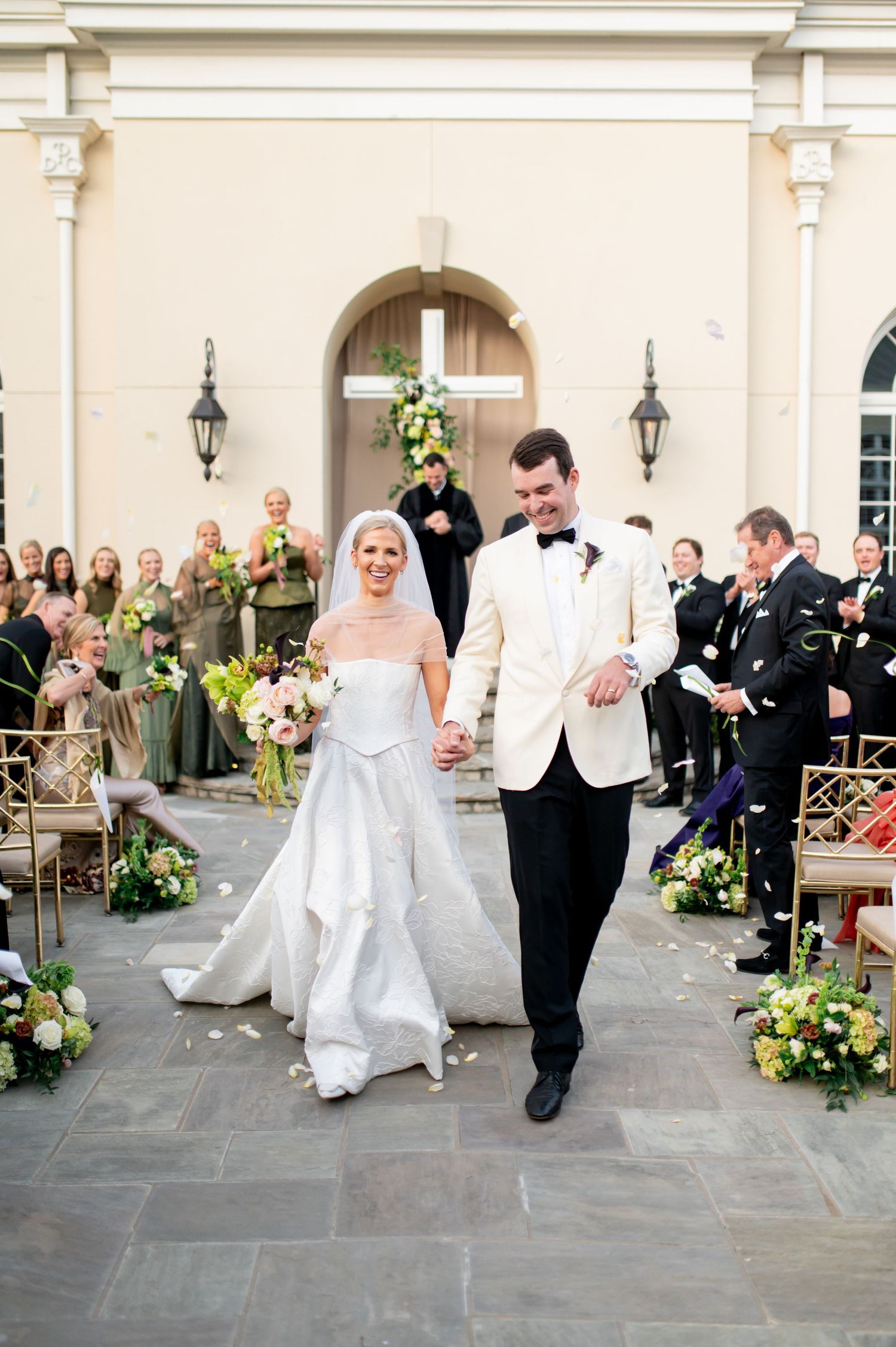 Elegant wedding couple dancing and twirling in a series of candid shots along a stone courtyard with floral decorations.