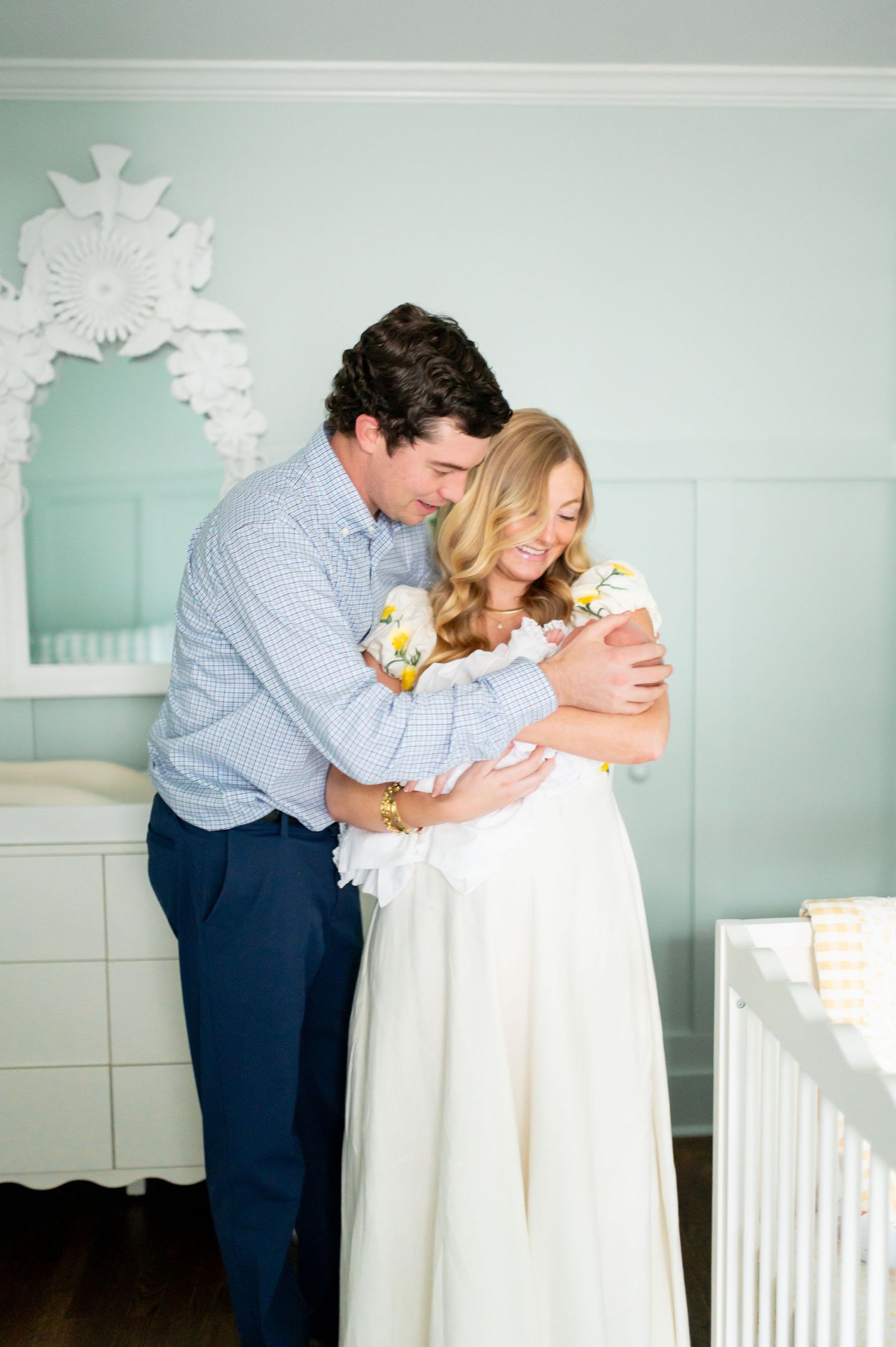 Sweet moments captured in a mint green nursery with decorative snowflakes on the wall.
