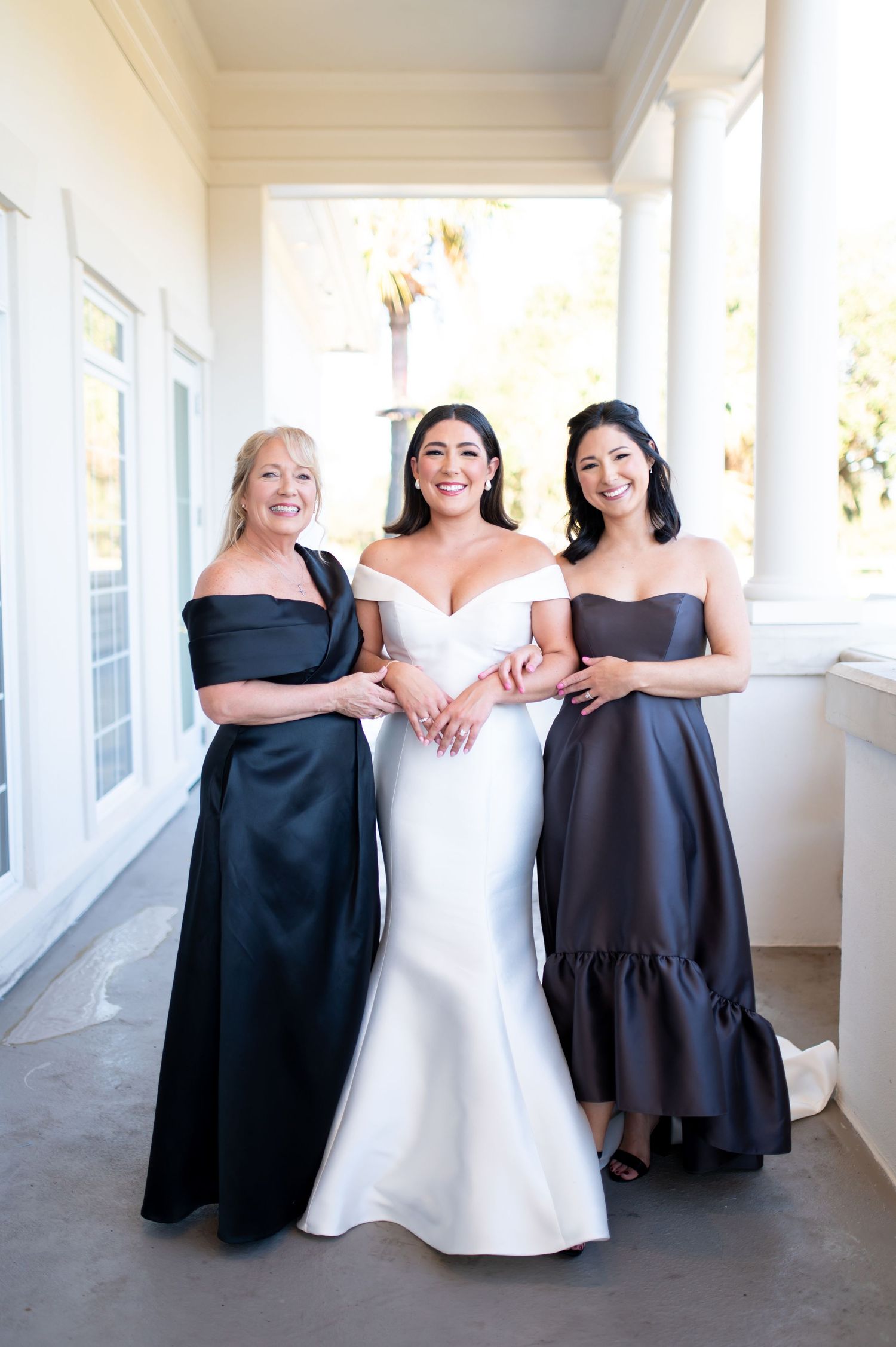 Wedding party wearing contrasting black and white dresses posing together on porch.