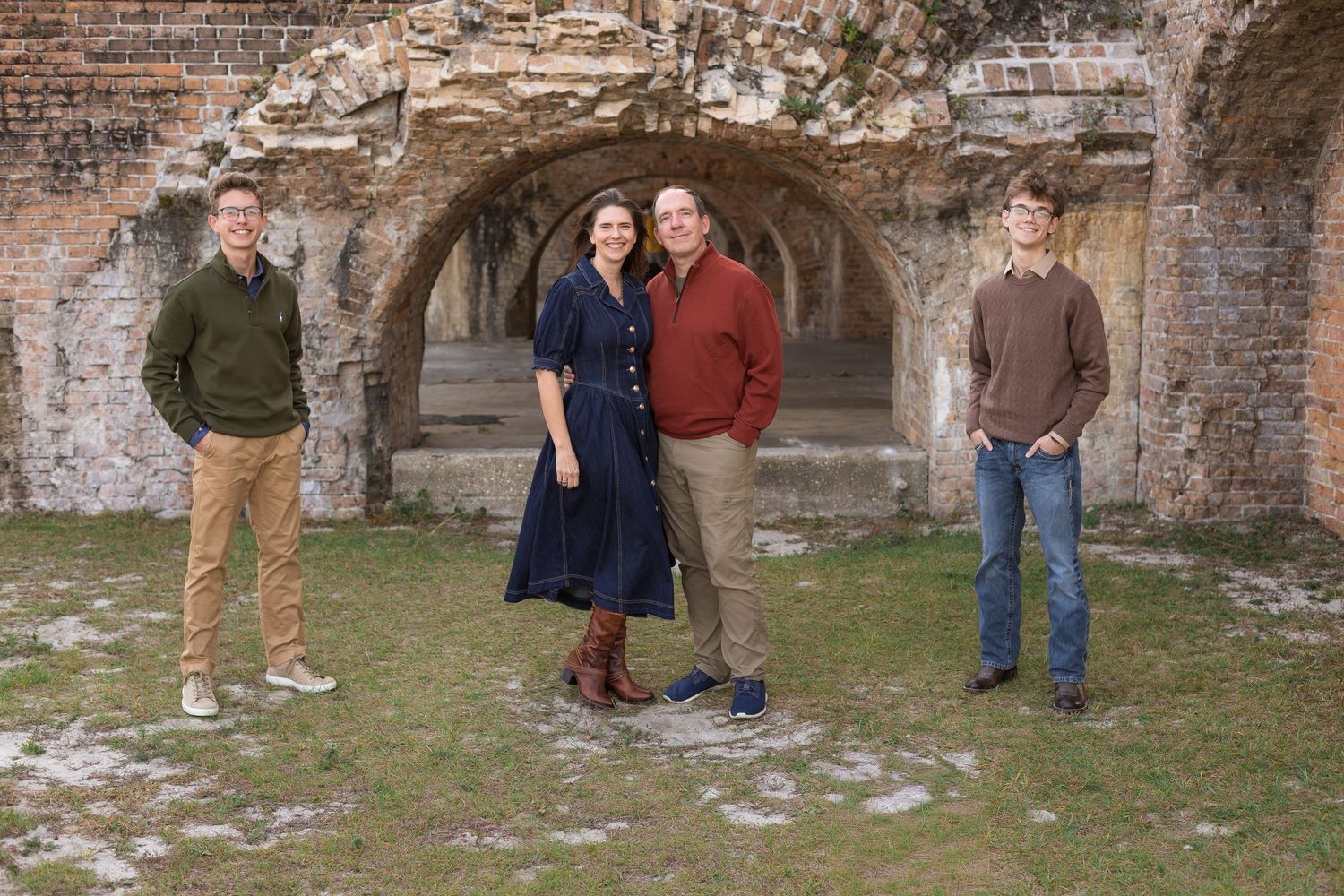 family posing in front of brick arch