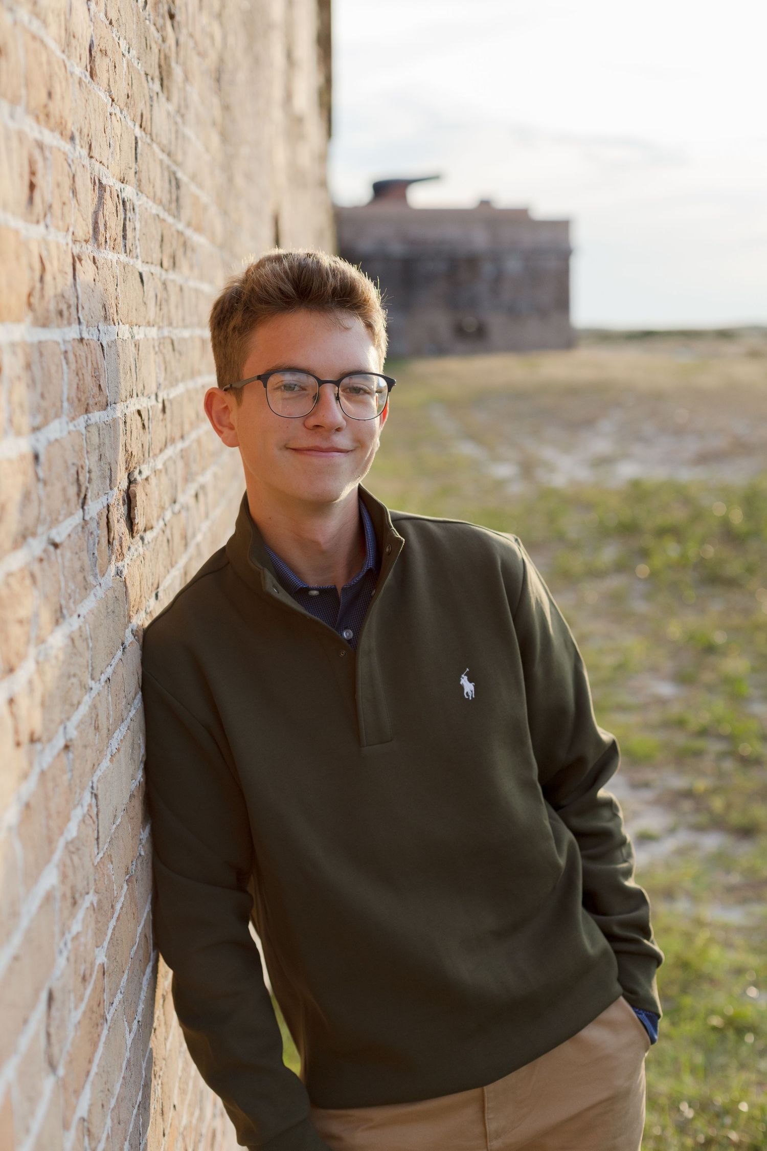 young man leaning against brick wall