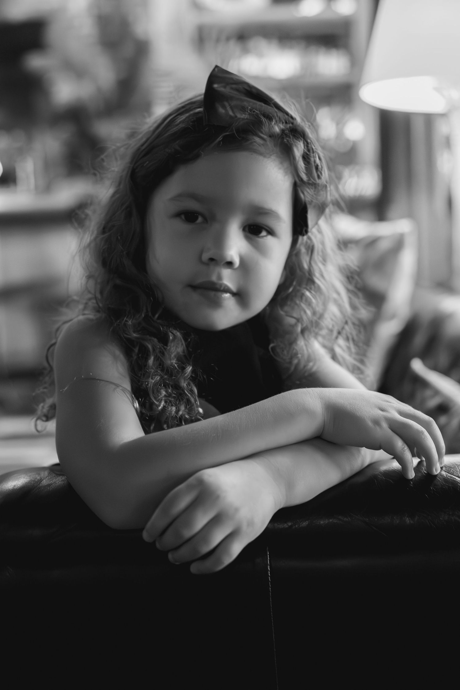 little girl looking over the arm of a couch