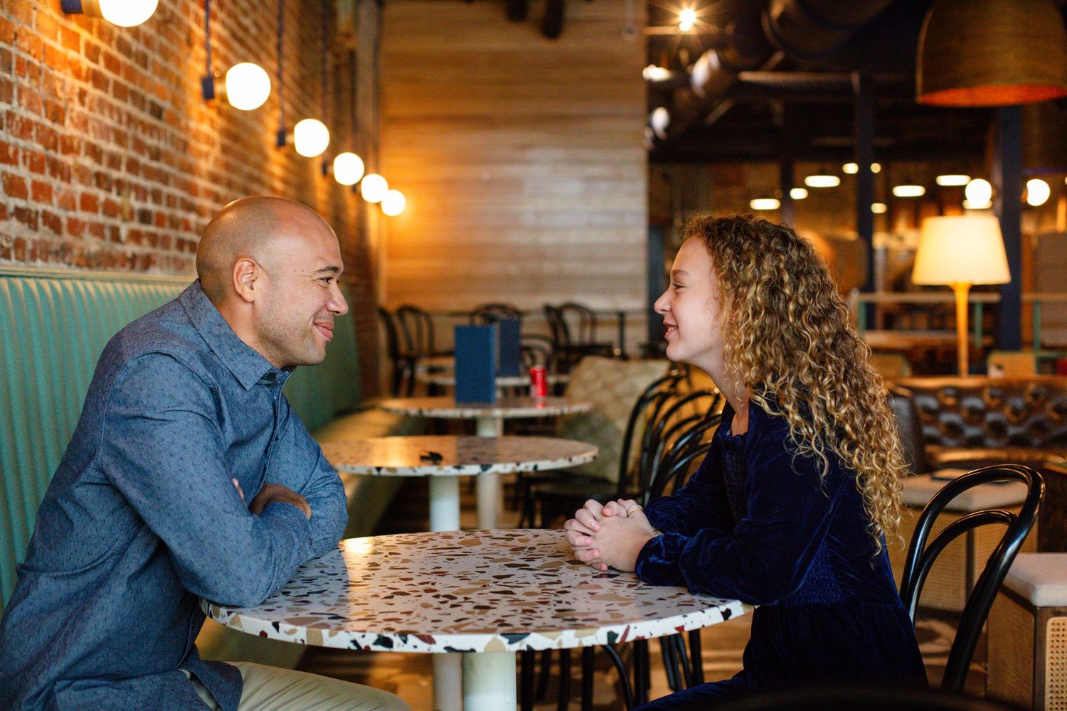 father and daughter looking at each other over a table