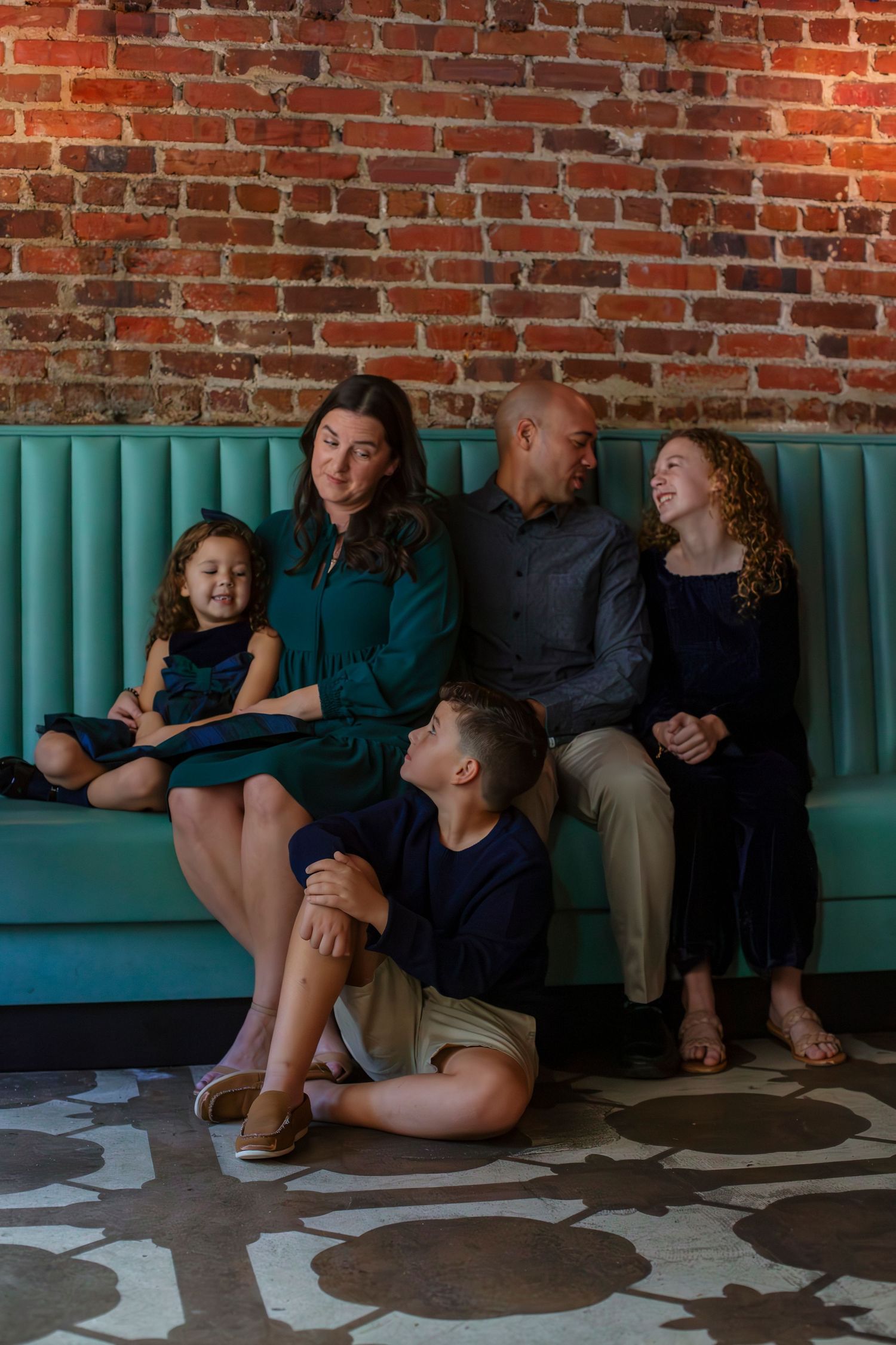 family cuddled on a couch looking at each other