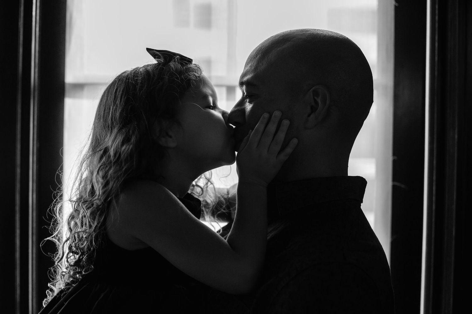 little girl kissing daddy
