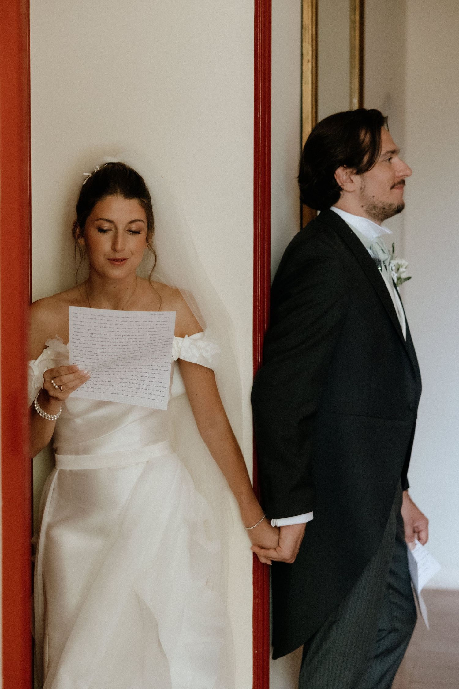 Couple exchanges letters while standing on opposite sides of a door before their wedding ceremony.